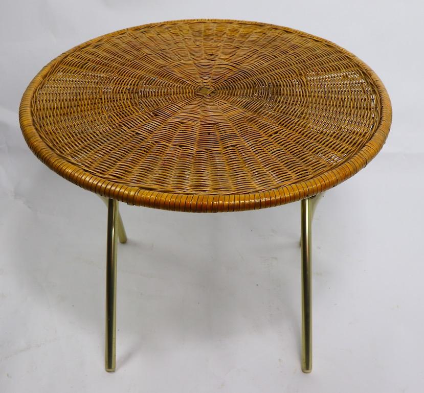 Stylish circular folding table by the Telescope Chair Company having a woven wicker top, and gold tone anodized aluminum legs. Sturdy, stylish and chic, also lightweight and portable, great for casual patio, poolside or porch use. Please view the