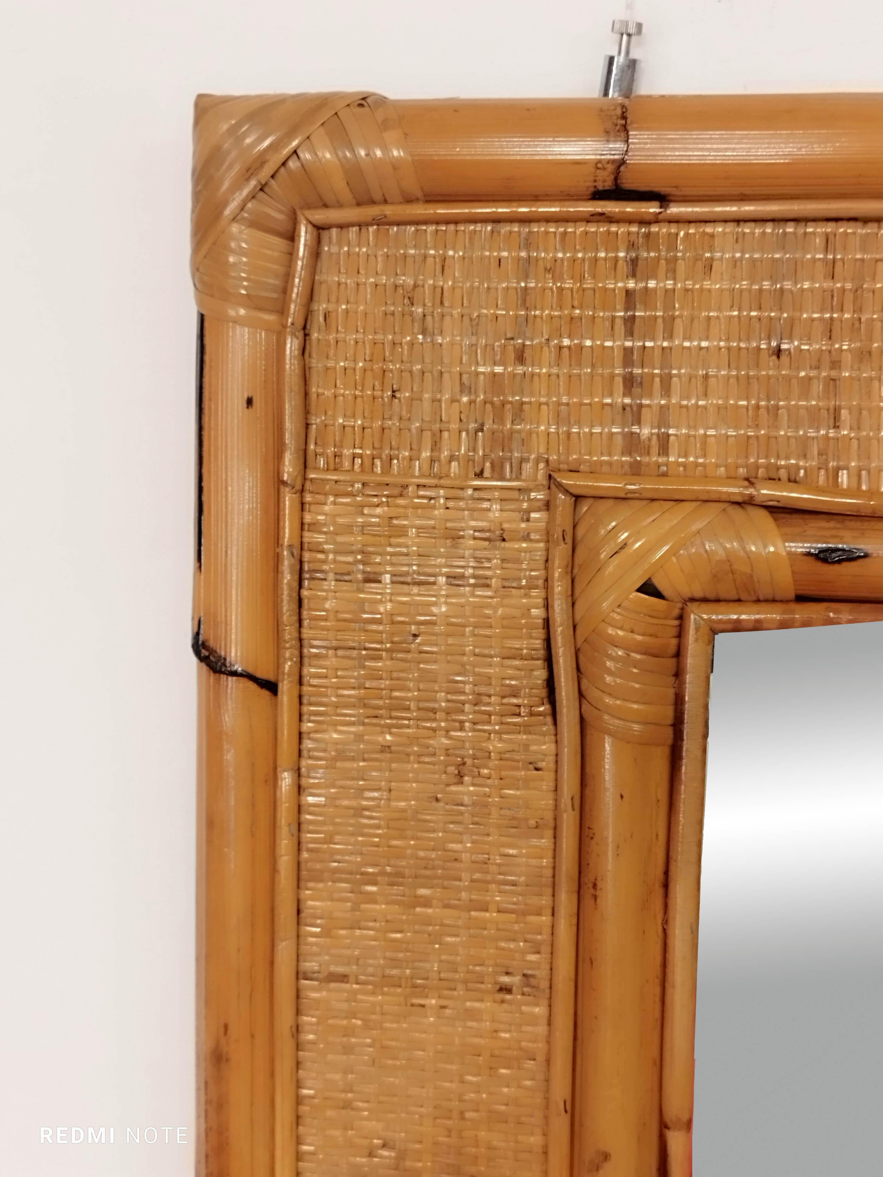 Bellissimo specchio rettangolare in canna di bambù e vimini intrecciato progettato in Italia negli anni '60.
Questo specchio è unico grazie alla sua splendida doppia cornice, composta da una cornice esterna in bambù più grande e da una cornice