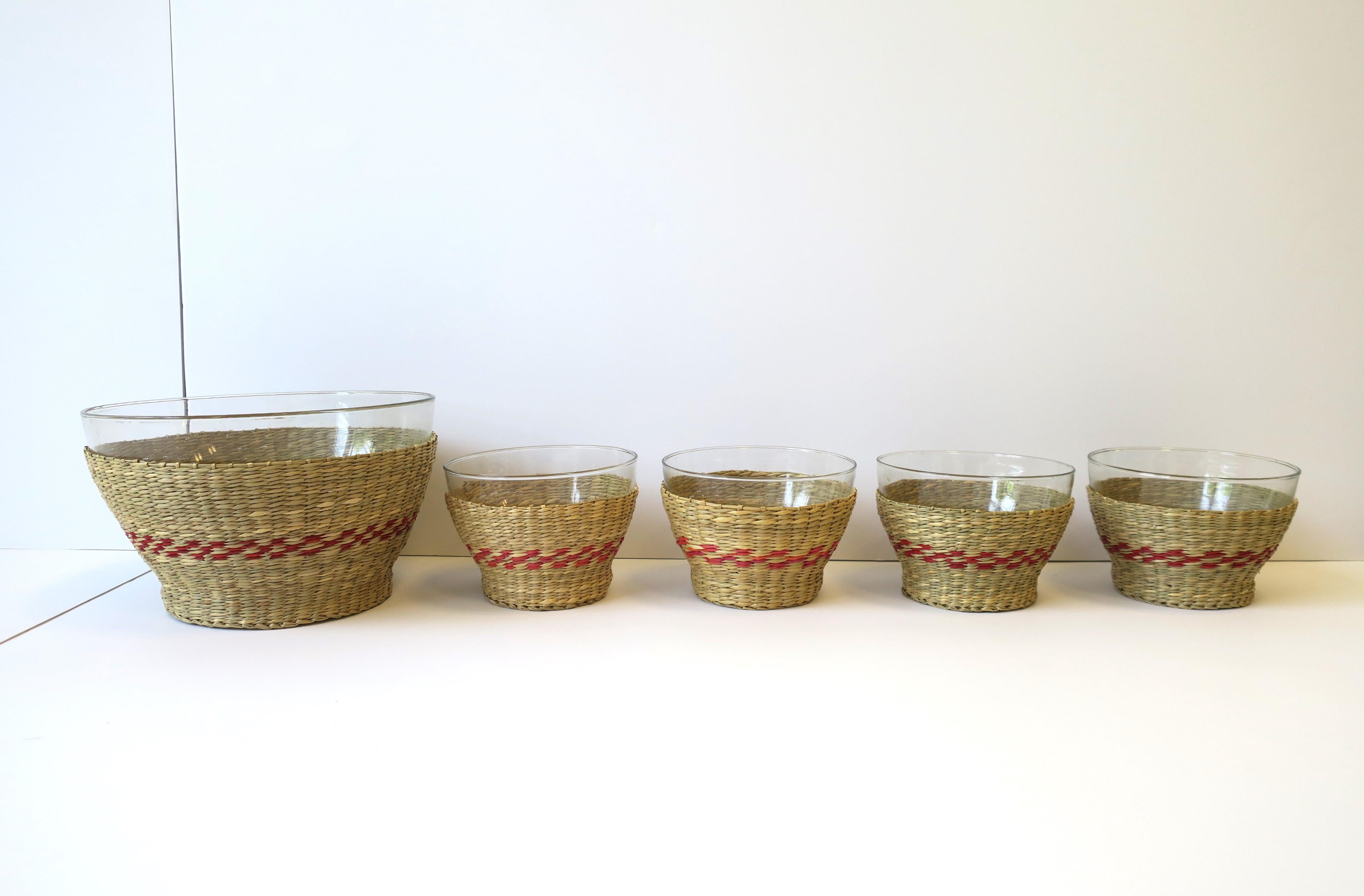 A wicker and glass bowl serving set. Set includes 1 large bowl and 4 smaller bowls, all embraced by a wicker 'basket' with red design around. Five (5) bowls in total. Great for everyday use or for entertaining, indoors or out. 

Dimensions: