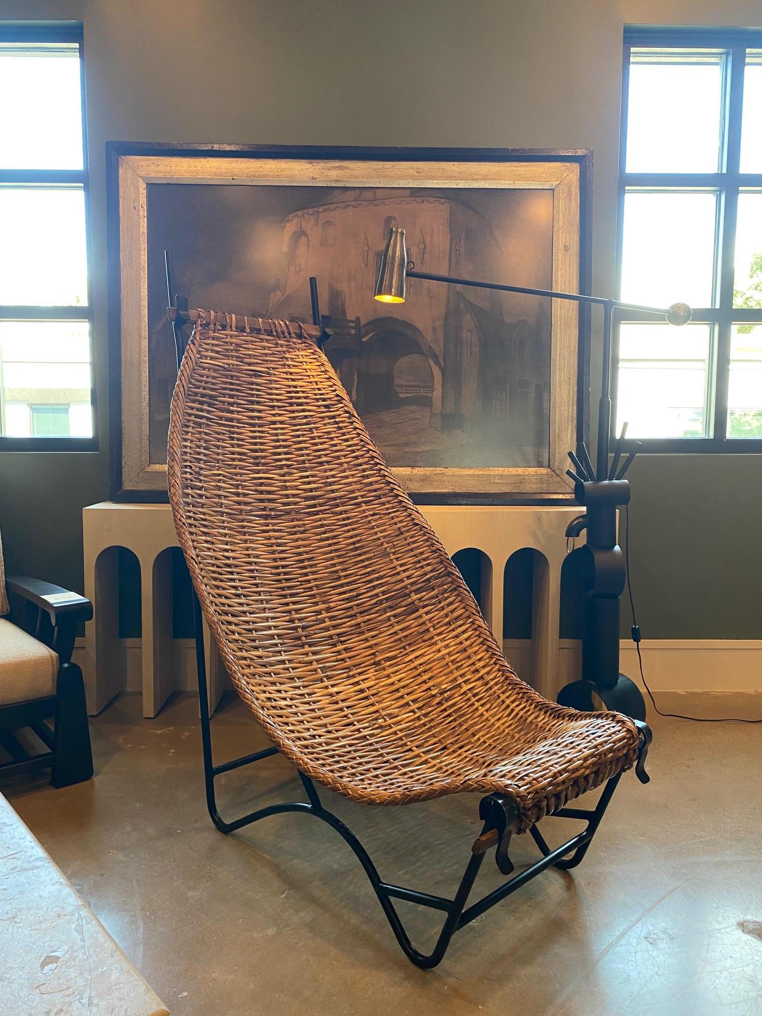 A fantastically sculptural mid-century chair indicative of the South of France's woven arts movement.  Sturdy wrought iron high back frame supports woven rattan sling.  Sling detaches from frame if needed.  France, 1950's 
