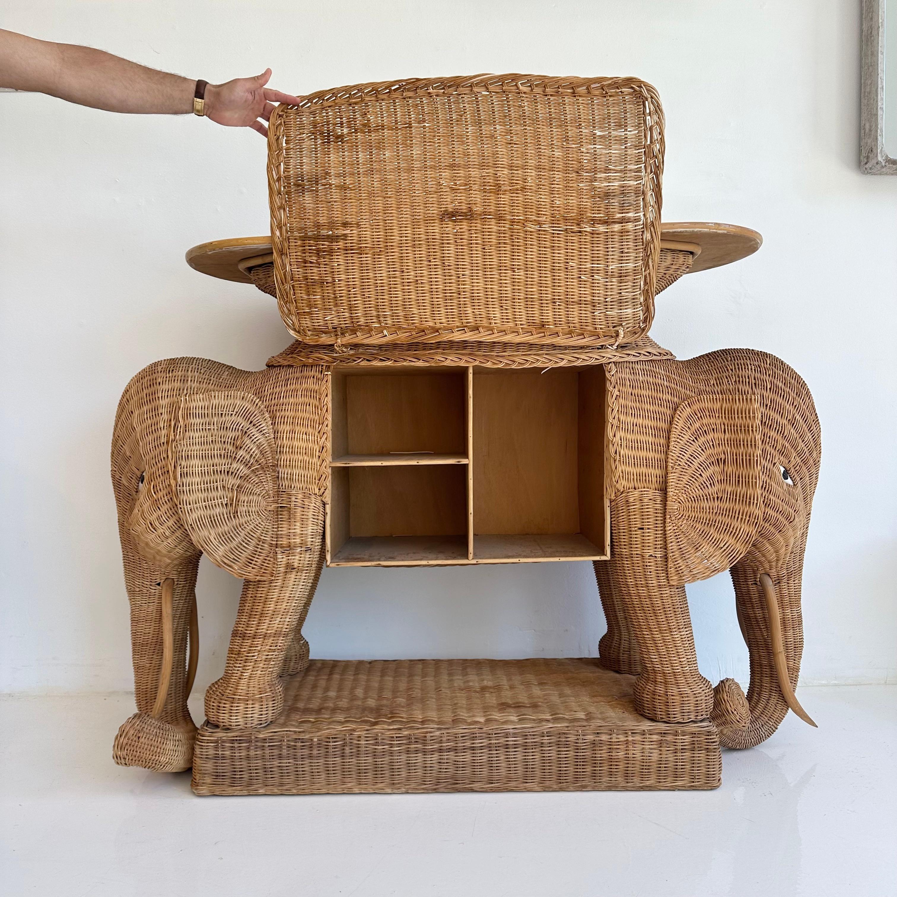 Atemberaubender, einzigartiger Konsolentisch aus Weide und Rattan. Mit zwei gespiegelten Elefantengesichtern an jedem Ende, die dem Stück eine schöne symmetrische Silhouette verleihen. Deckel aus Emaille. Wunderschöne Details und handwerkliches