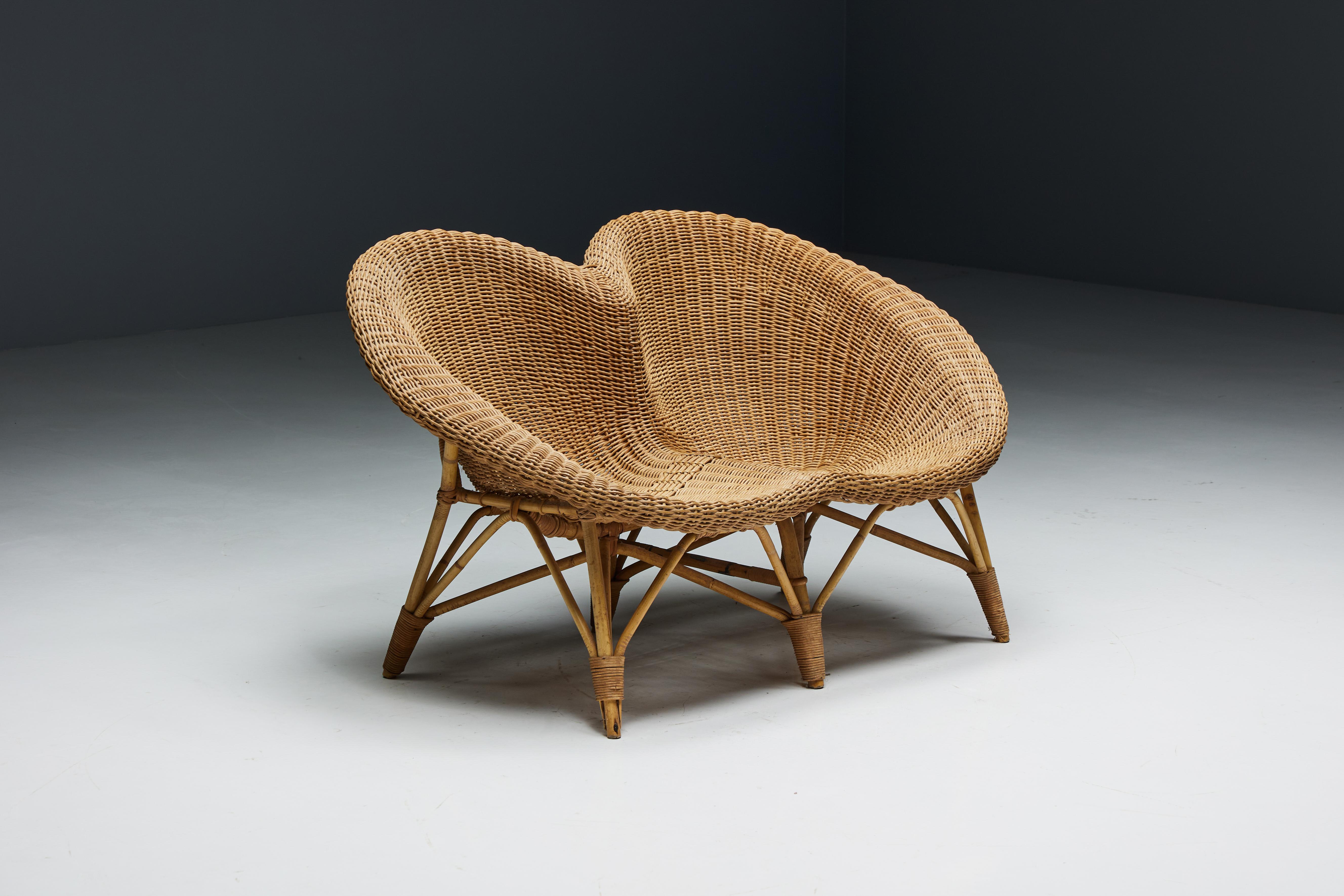Italian loveseat from 1970, made of a wicker seat and sturdy rattan frame and legs. The unique design consists of two cone-shaped chairs that blend seamlessly, creating a visually captivating focal point for any room.