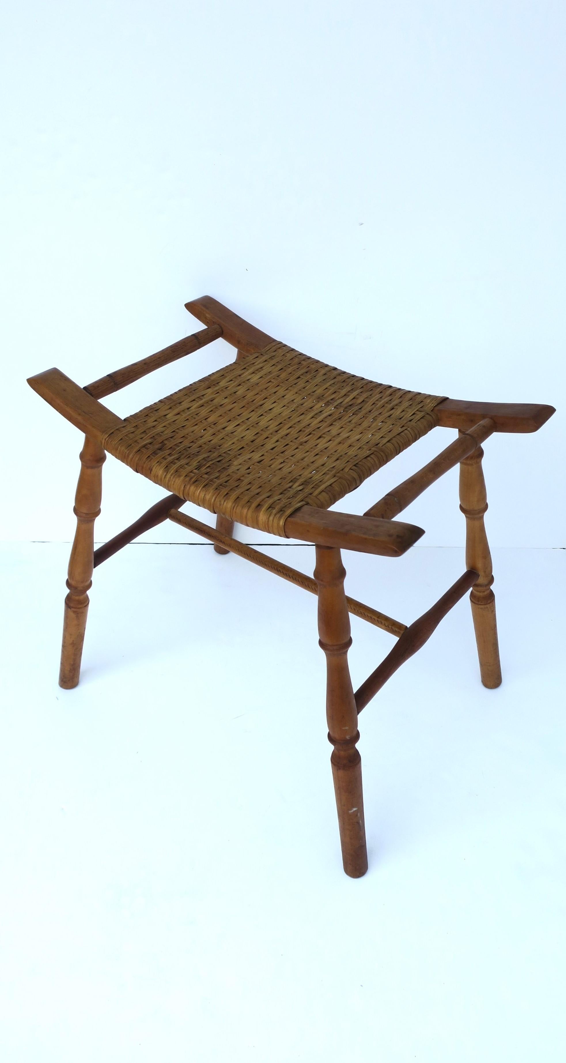 A wicker and oak wood turned stool, in the Victorian style, circa mid-20th century USA. Piece is rectangular with a wicker seat and turned legs. Great as a seat/stool or to hold/display books, a cocktail, plant, etc. 

Overall Dimensions: 14.25
