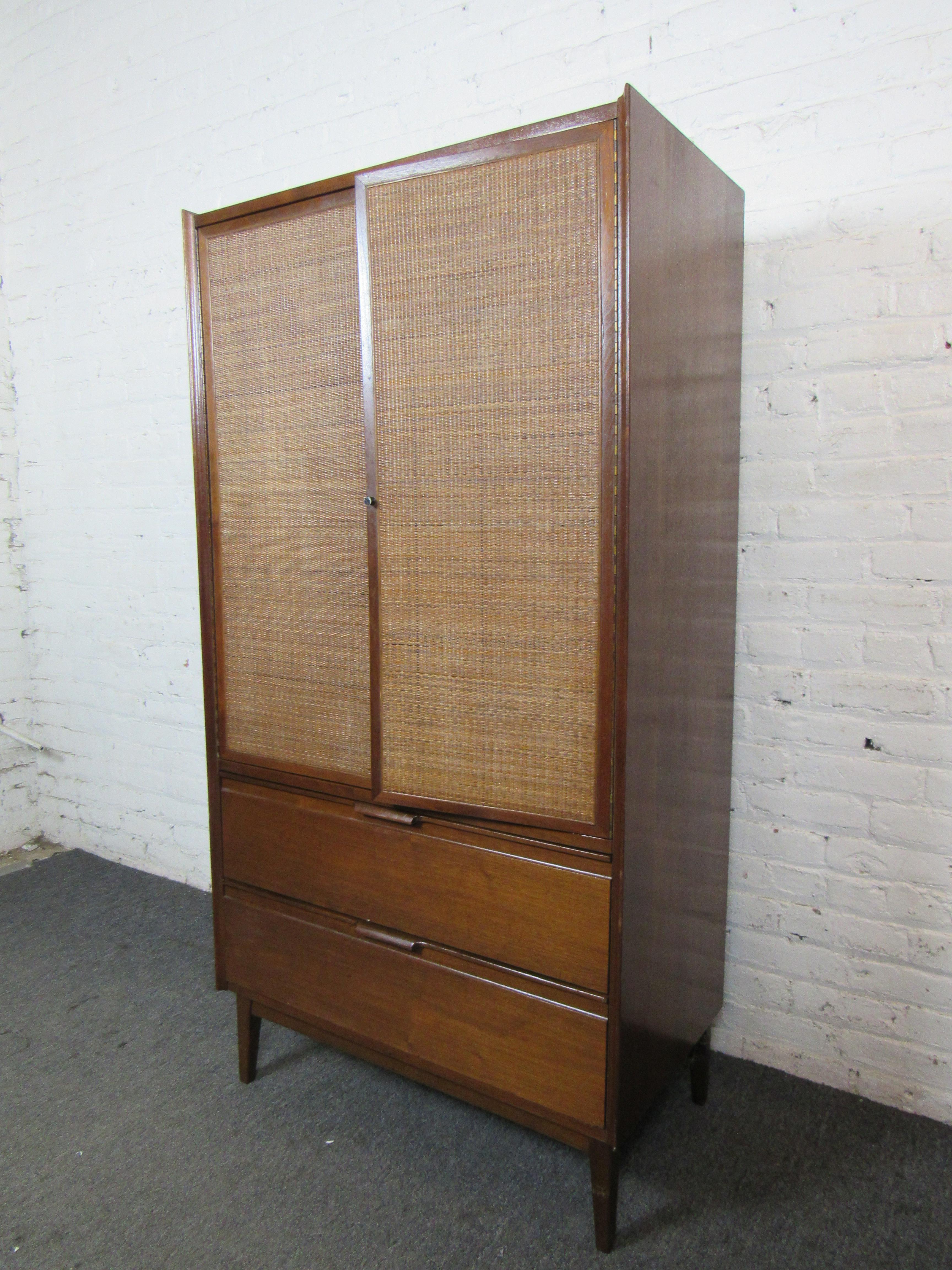 This large armoire by American of Martinsville features woven wicker panels paired with rich walnut for a unique look. 
Please confirm item location with seller (NY/NJ).