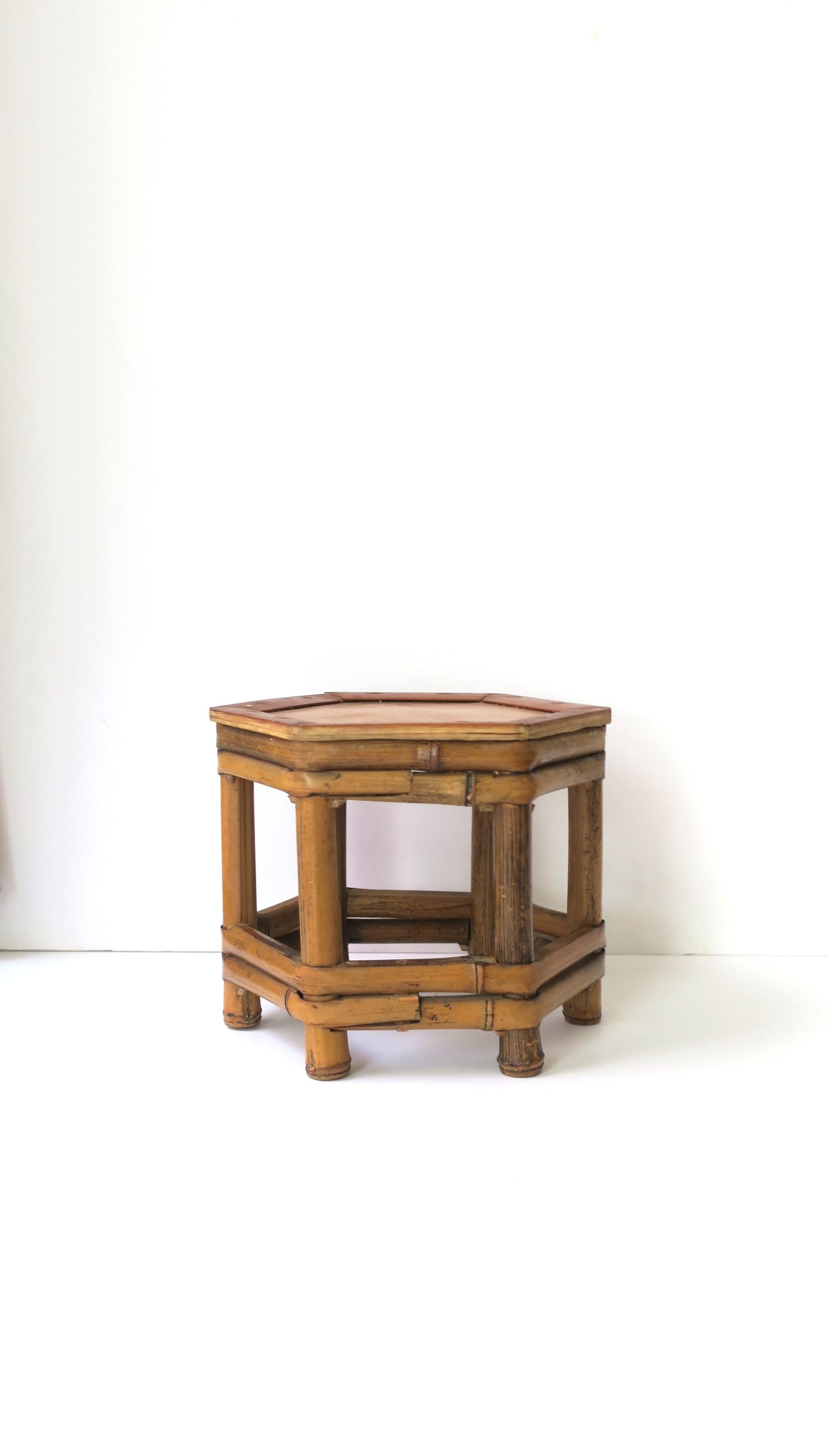 A hand-crafted mini, low, wicker bamboo pedestal drink table/stand or plant stand, etc., circa 1970s, Asia. Piece has a 'hexagon' shape, which is a nice alternative to round or square. A great piece to hold a drink, books, plant, etc. Piece is