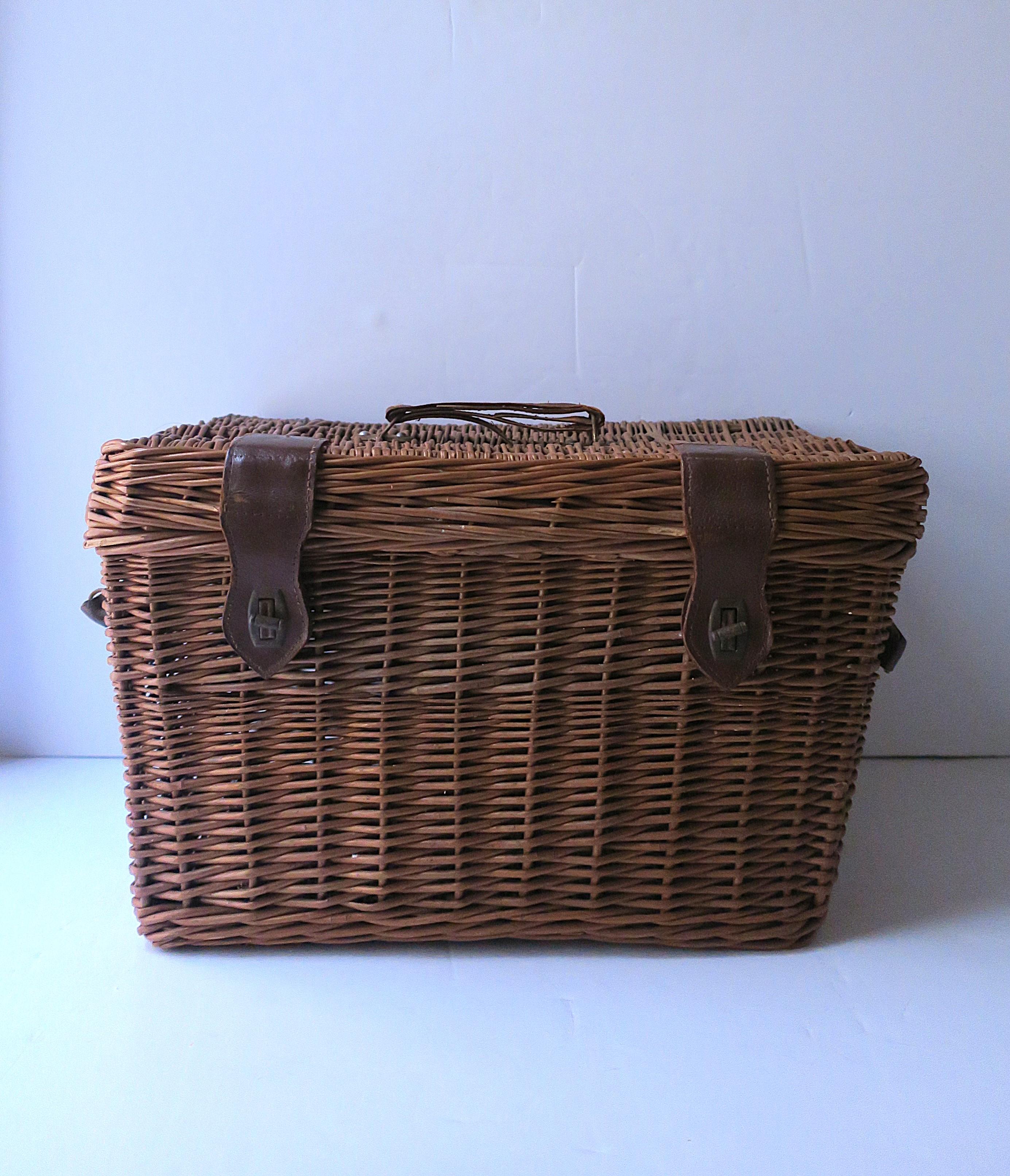 Panier européen vintage en osier (peut-être un panier de pique-nique) avec des sangles en cuir et des fermetures en métal torsadé, vers le début ou le milieu du 20e siècle, Yougoslavie. Le panier est de forme rectangulaire et est constitué de