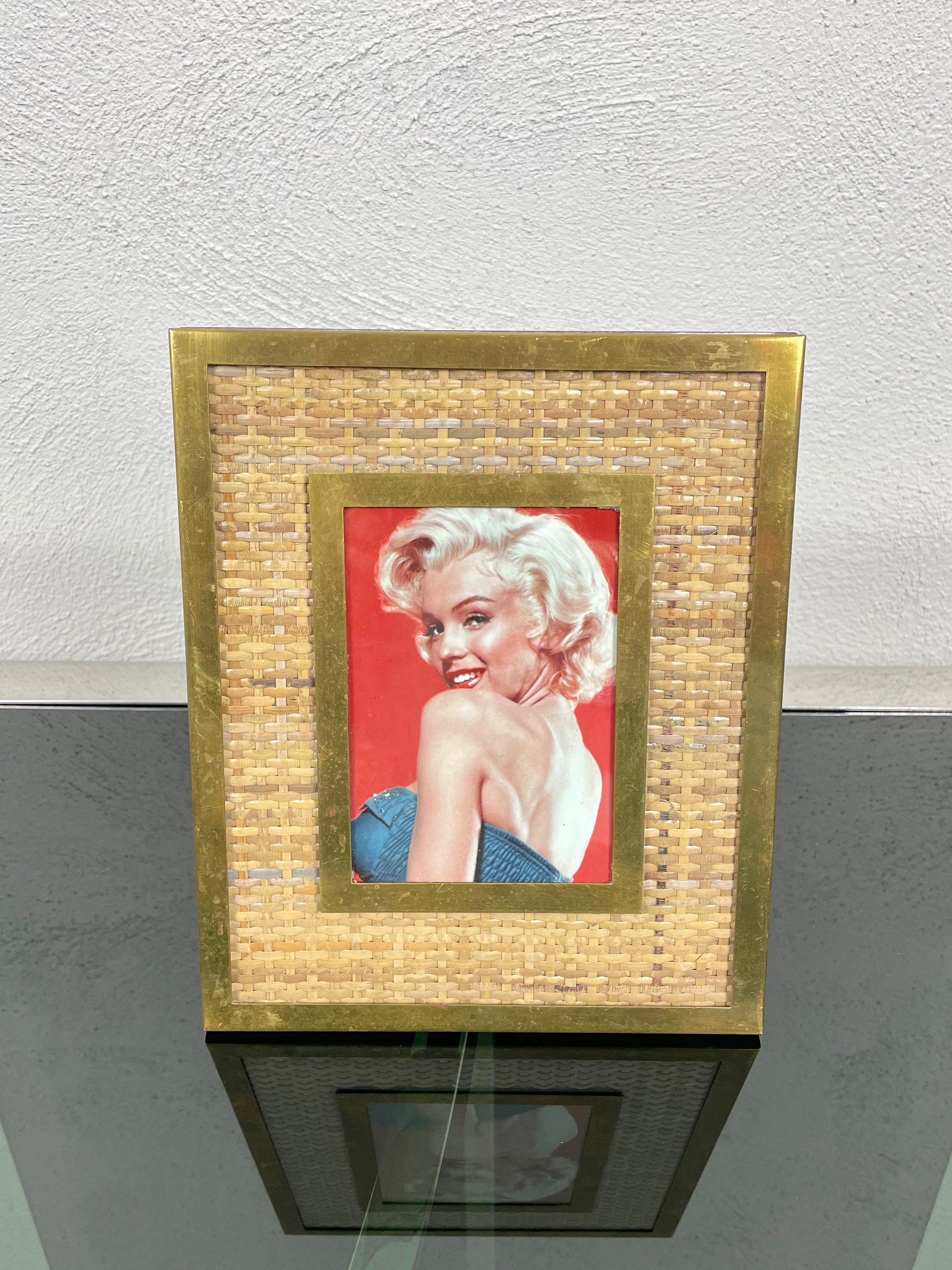 Rectangular picture frame in wicker bordered in brass supported by a wooden structure. Made in Italy in the 1960s.