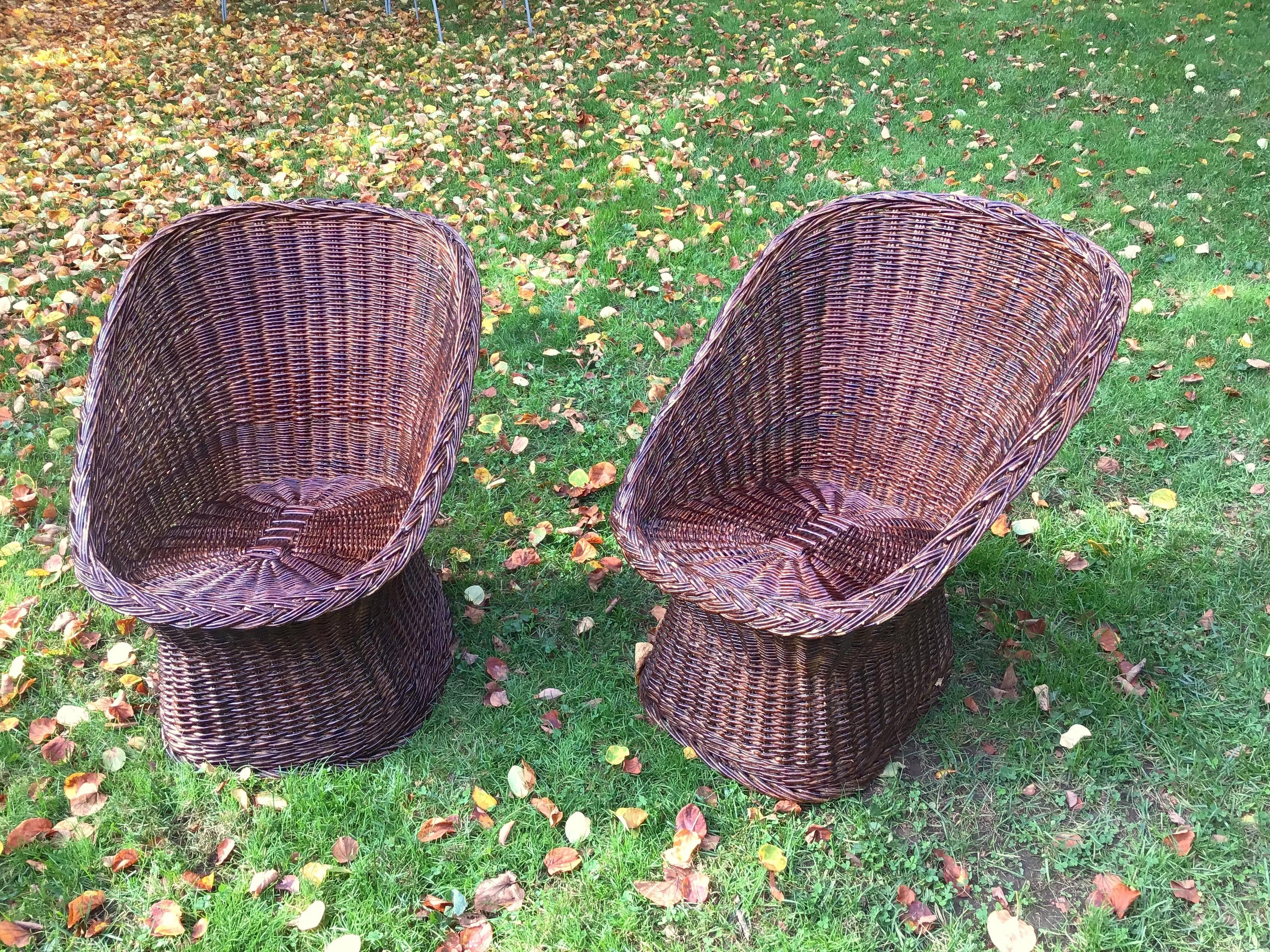 Une paire de fauteuils seau vintage en osier, rotin rétro, brun foncé.