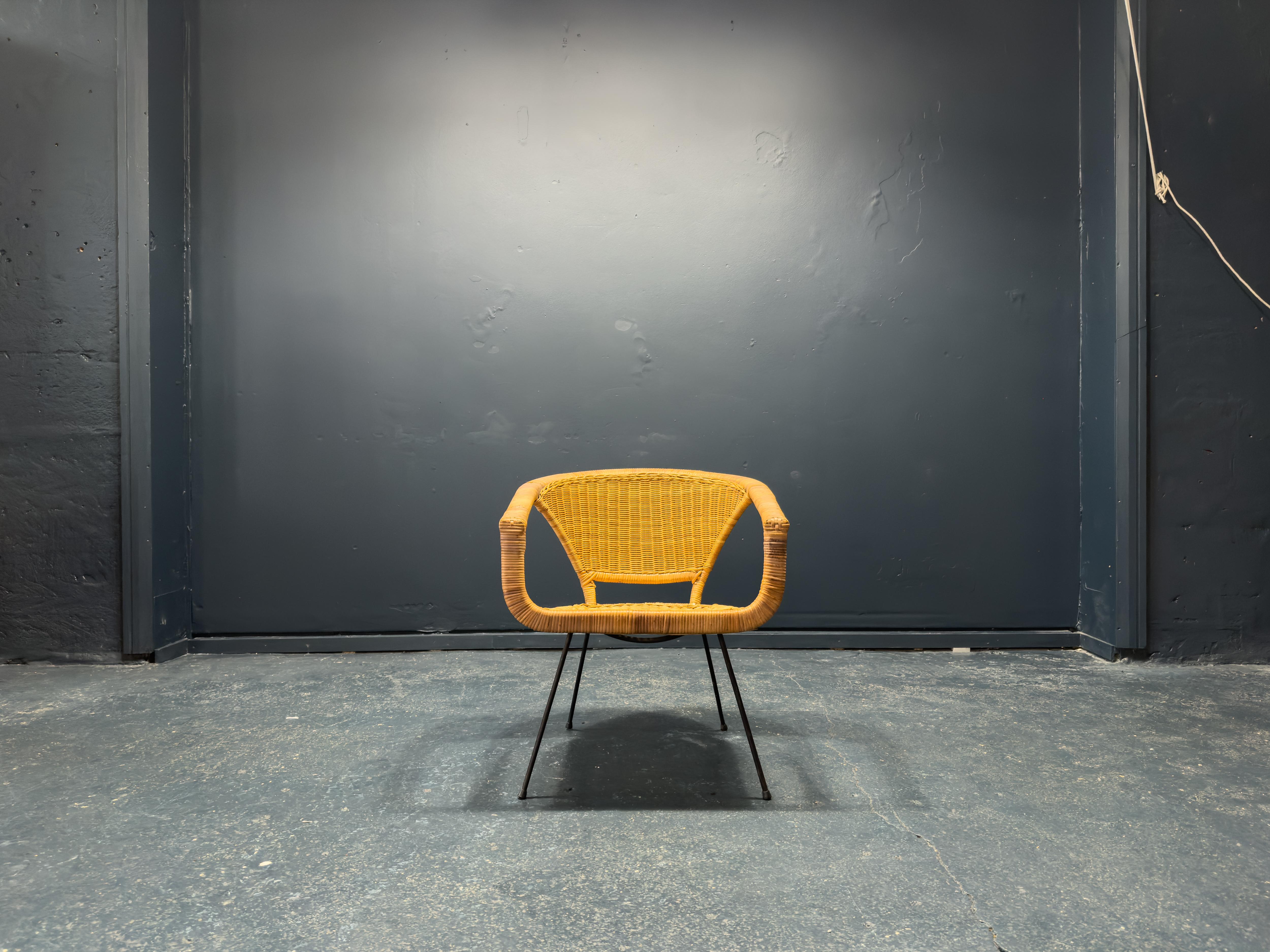 Con un ampio carattere, questa semplice sedia in vimini è un pezzo splendido. Sebbene il design sia semplice, la natura minimale dell'opera è il suo campione, con forti linee angolari che utilizzano lo spazio negativo all'interno della cornice per