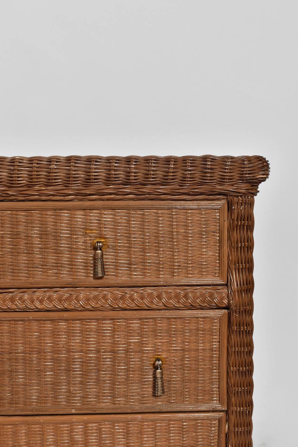 Wicker chest of drawers opening with seven drawers ornamented with bronze pompons handles. France, 1970s.