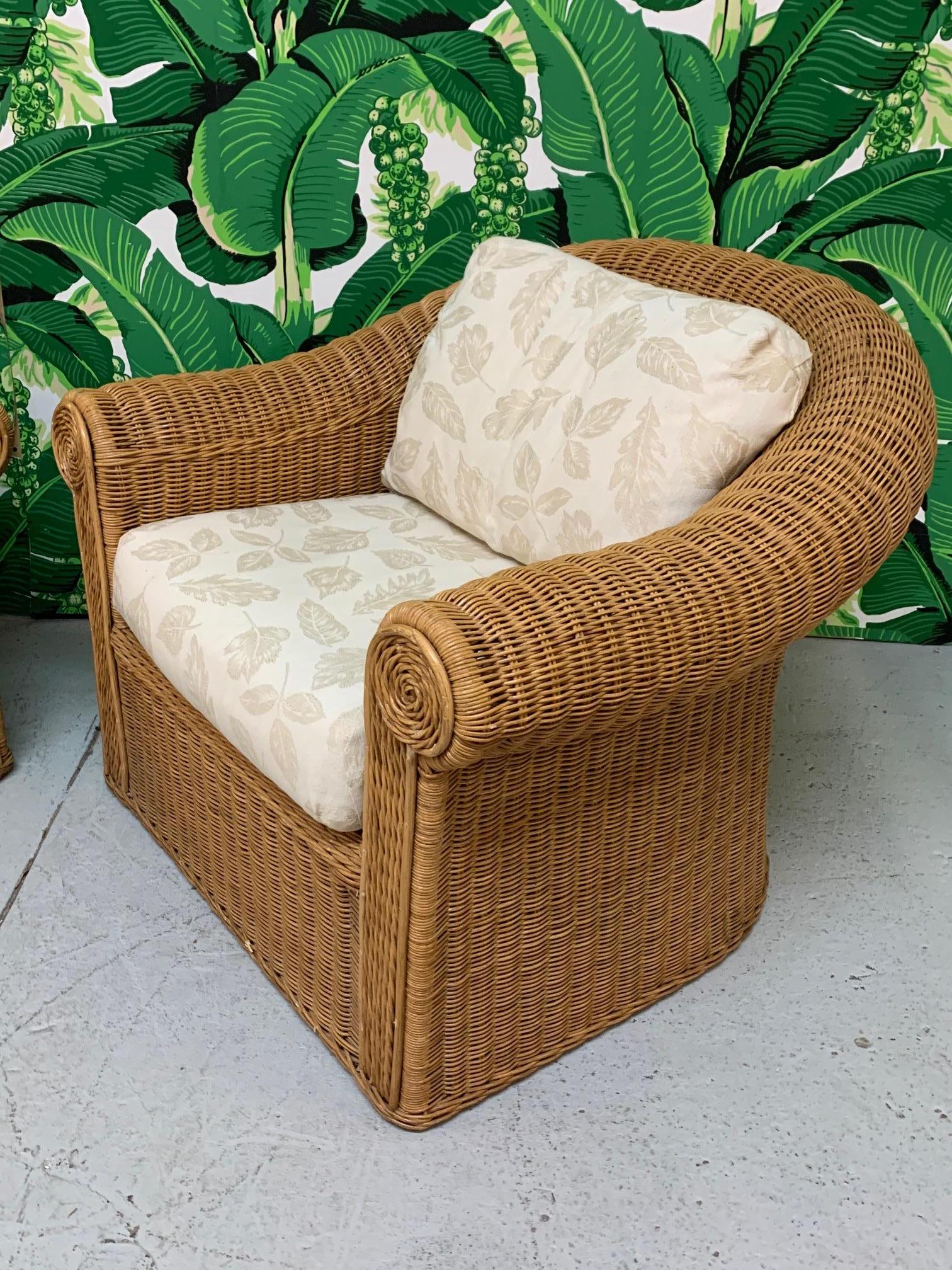 Pair of vintage wicker club chairs in the manner of Michael Taylor feature sculptural design and neutral upholstery. Very good condition both structurally and cosmetically. Seat height is 17