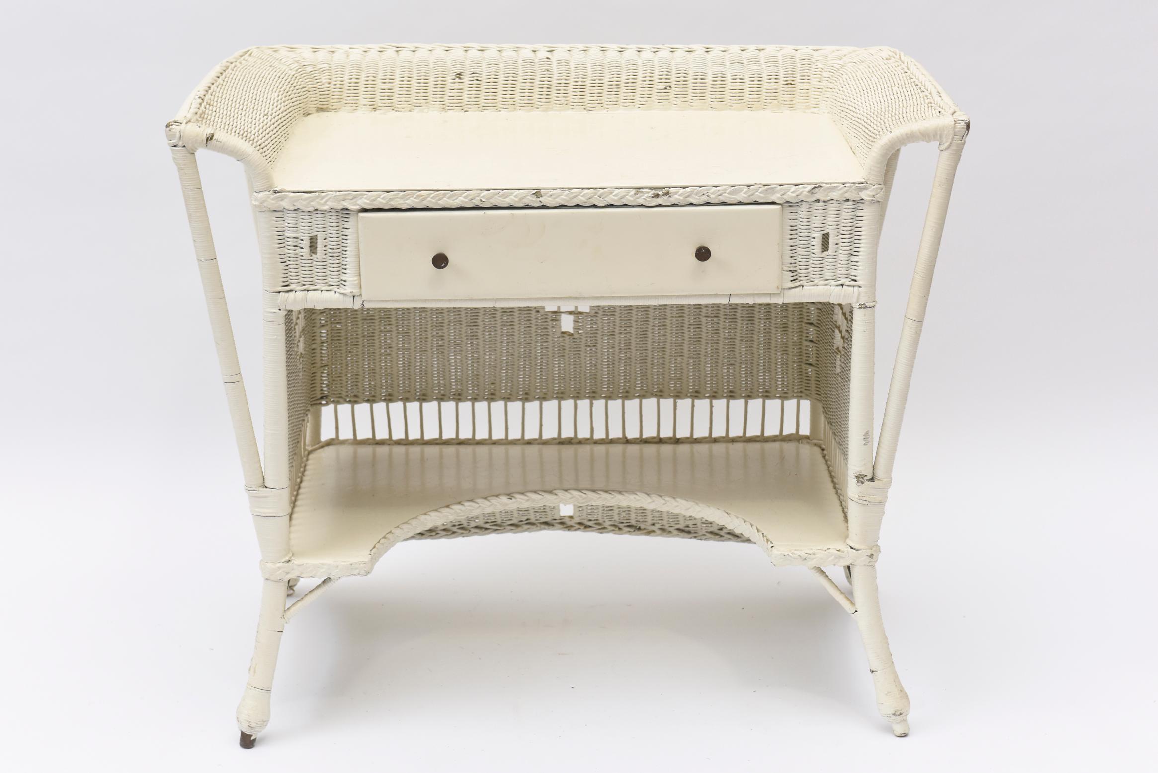 Typical of 1930's, this desk has both diamond shapes and crosses woven into its sides. Just above the bottom shelf is openwork with sticklike spindles all around. It has one drawer which is tightly woven. The ball feet are woven and around the