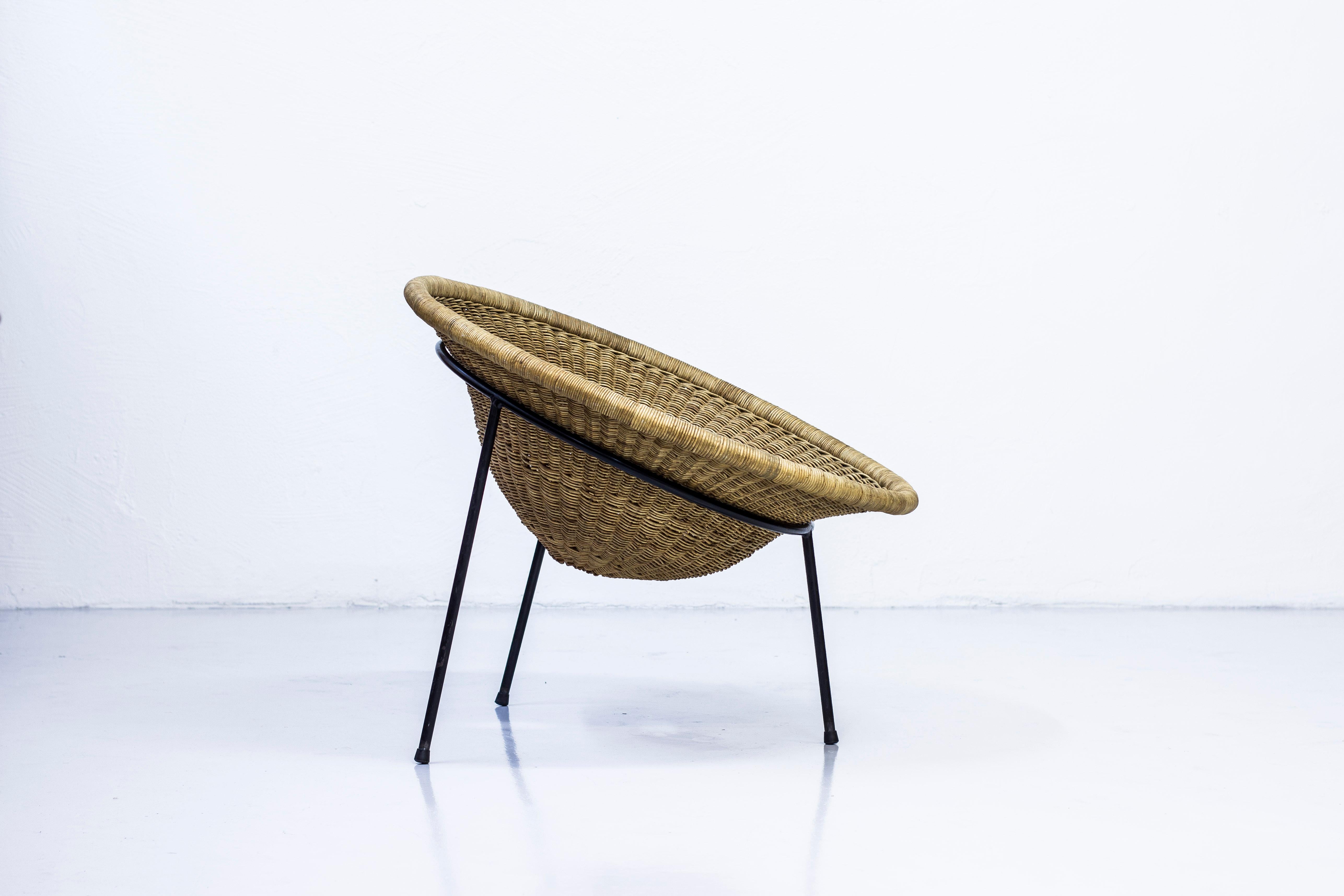 Easy chair attributed to Sven Staaf. Produced by Staaf & Almgren, circa 1954 in Sweden. Made from handwoven wicker on a black lacquered metal frame. Very good vintage condition with few signs of wear and light age related patina.

The chair is