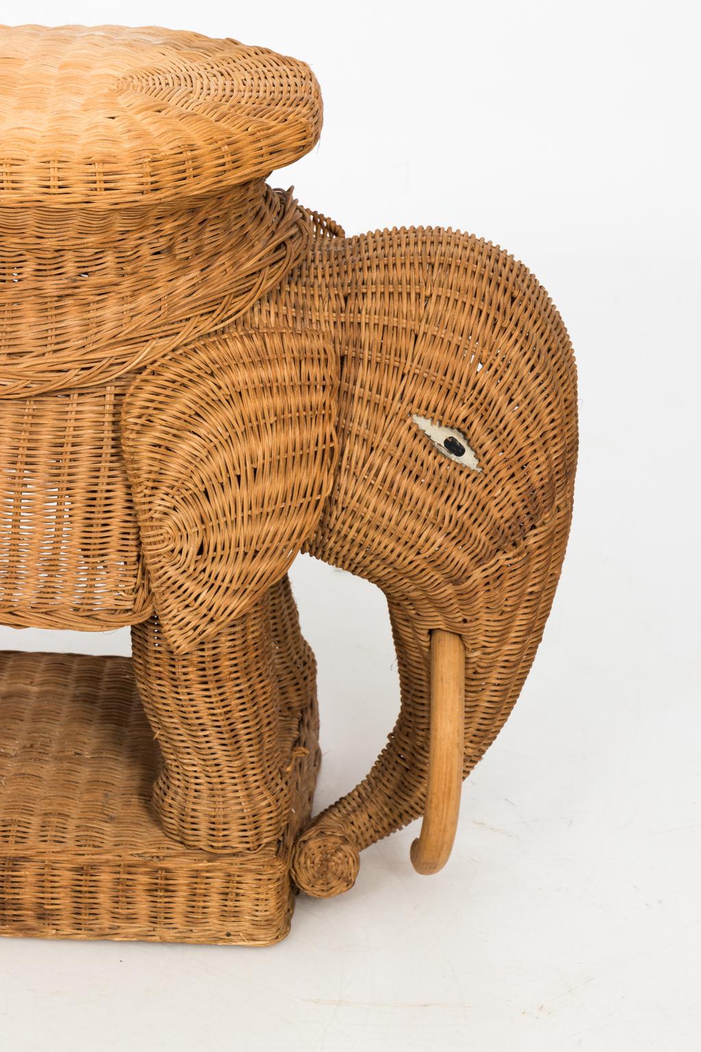 Circa 1960s woven wicker elephant occasional table with hand-painted eyes and wooden tusks. 