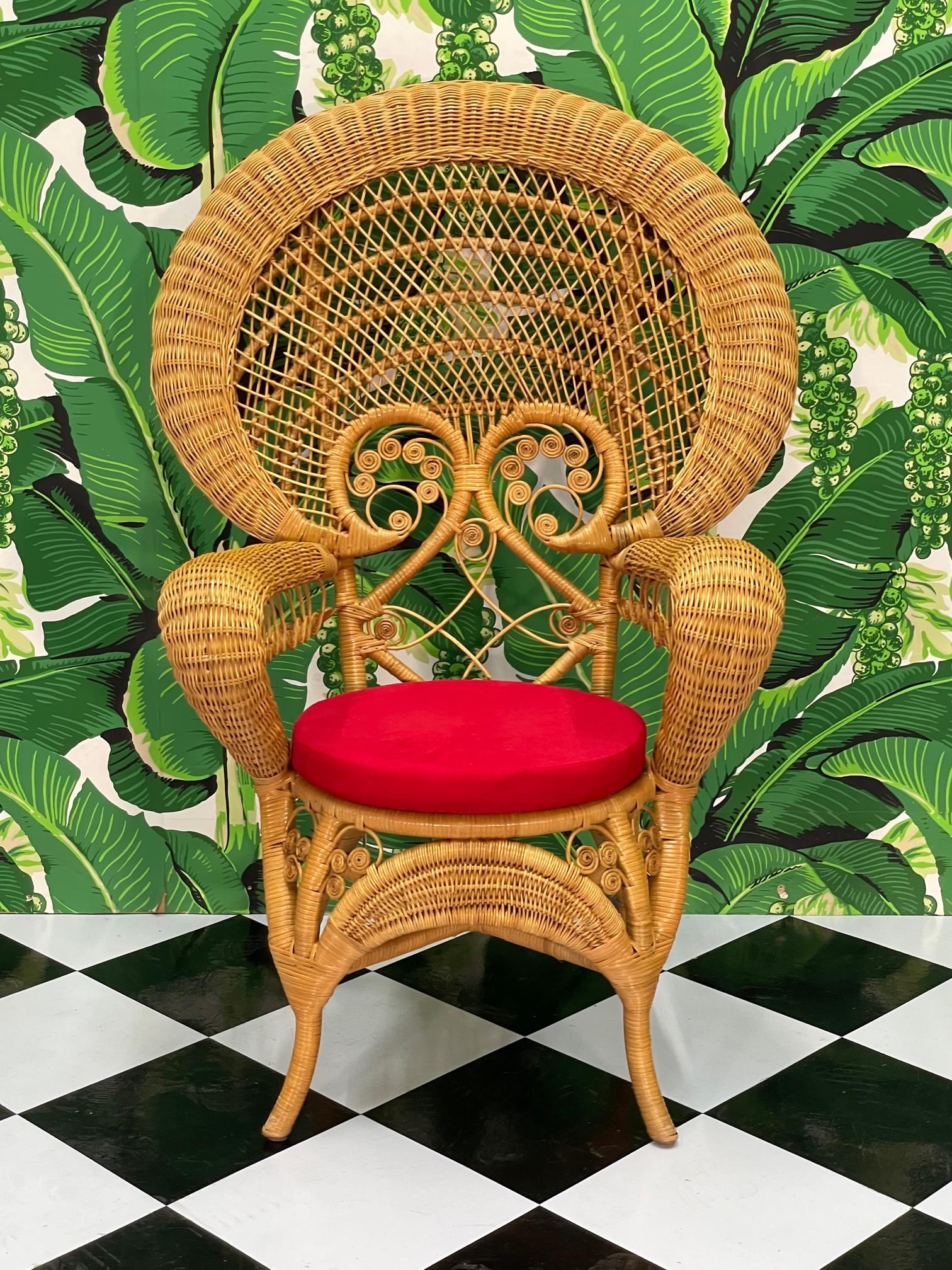 Woven wicker peacock or Emmanuelle chair features decorative fiddlehead style details and a removable red cushion. Good condition with minor imperfections consistent with age, see photos for condition details. Seat height is 17.5