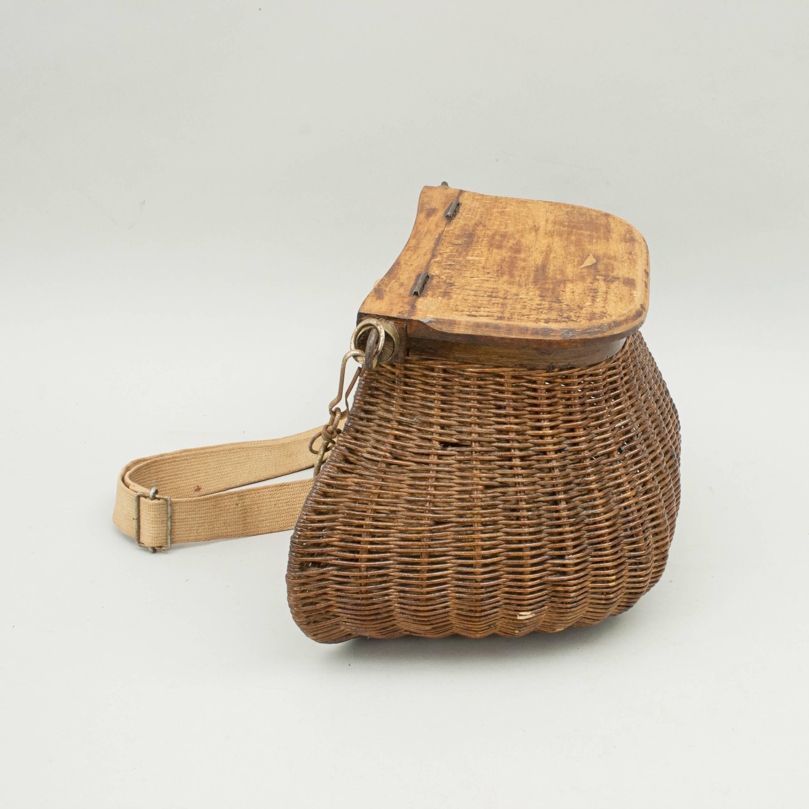 Vintage wicker and wood creel.
A very good example of an early wicker pot bellied fishing creel. The creel is made in the traditional design but with a hinged wooden lid with catch, wooden bottom, wooden rim around the top edge of the basket and a