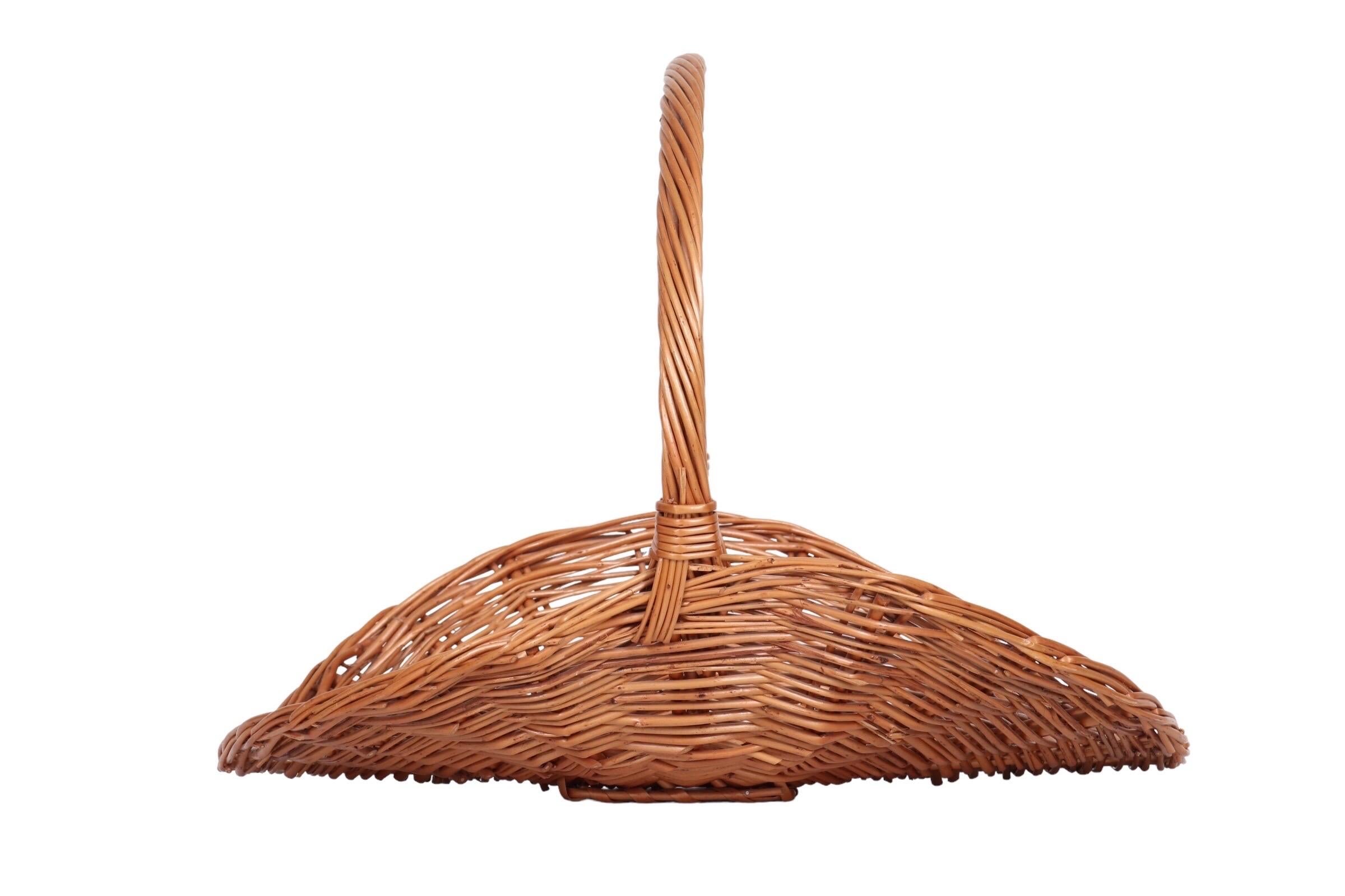 A French style, oval shaped gathering basket made of woven wicker. A tall round handle is tightly woven with a banded detail. Traditionally used for gathering flowers and herbs from the garden.
    