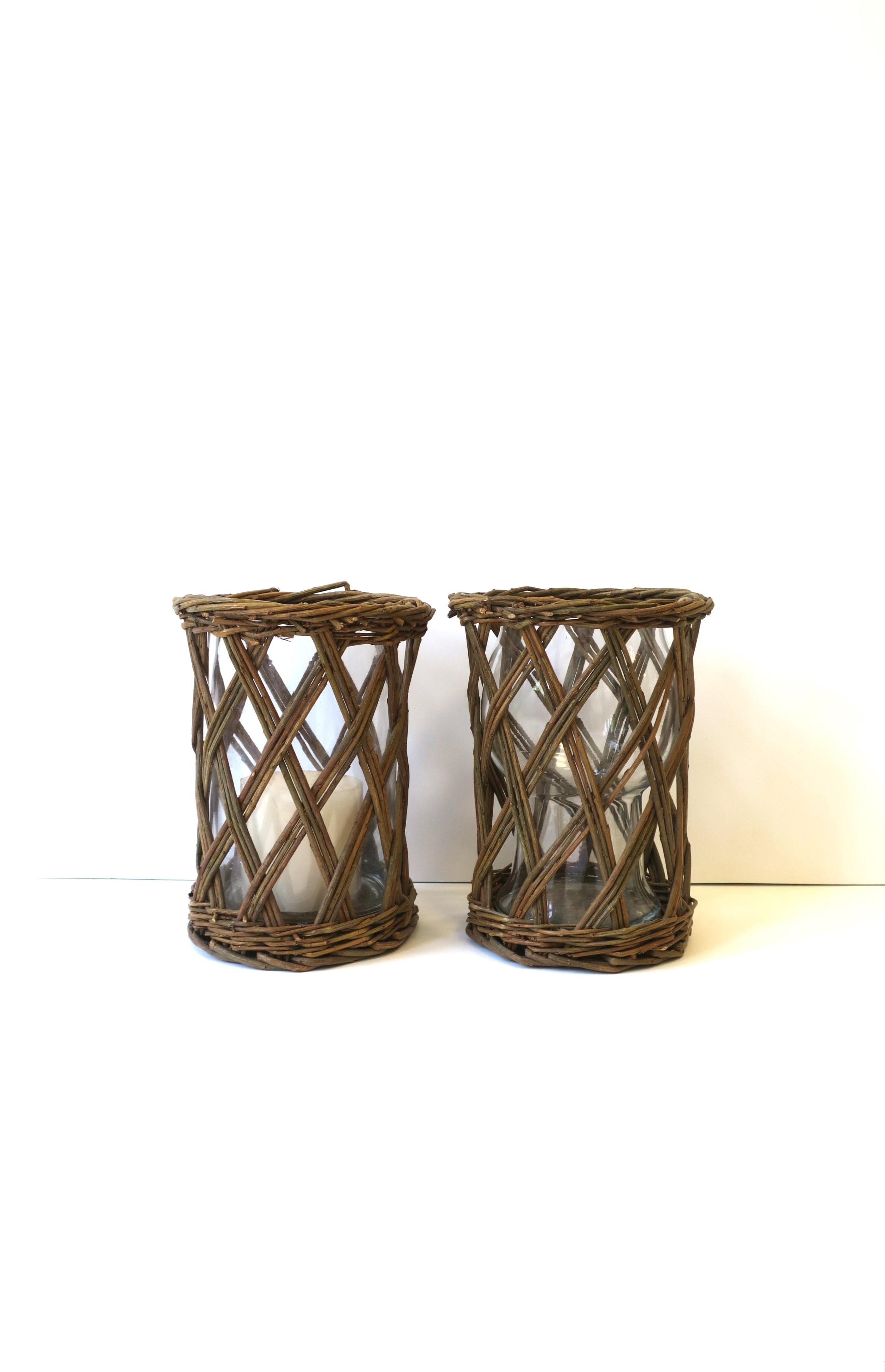 A set of two (2) wicker twig hurricane candle lamps. Set of wicker twig holders have a lattice 'X' design and glass inserts. Great for indoors or out, with many uses, e.g., dining table, steps, walkway, patio, terrace, etc. 

Dimensions: 6.5