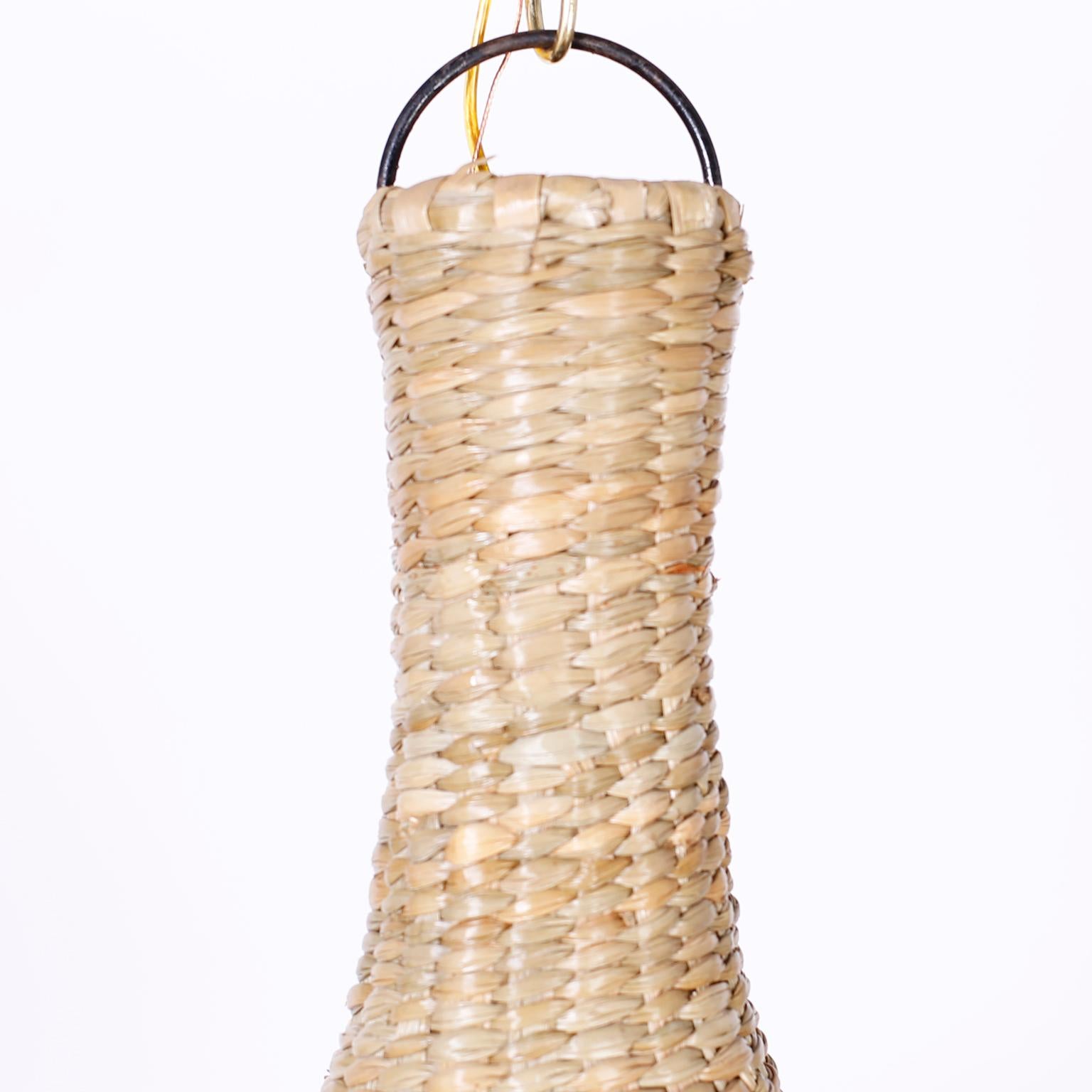 Wicker pendant or light fixture in the form of an inverted lotus flower crafted in the highest quality with a metal frame wrapped in reed from the FS Flores collection, exclusively designed and offered by F. S. Henemader Antiques. Constructed of