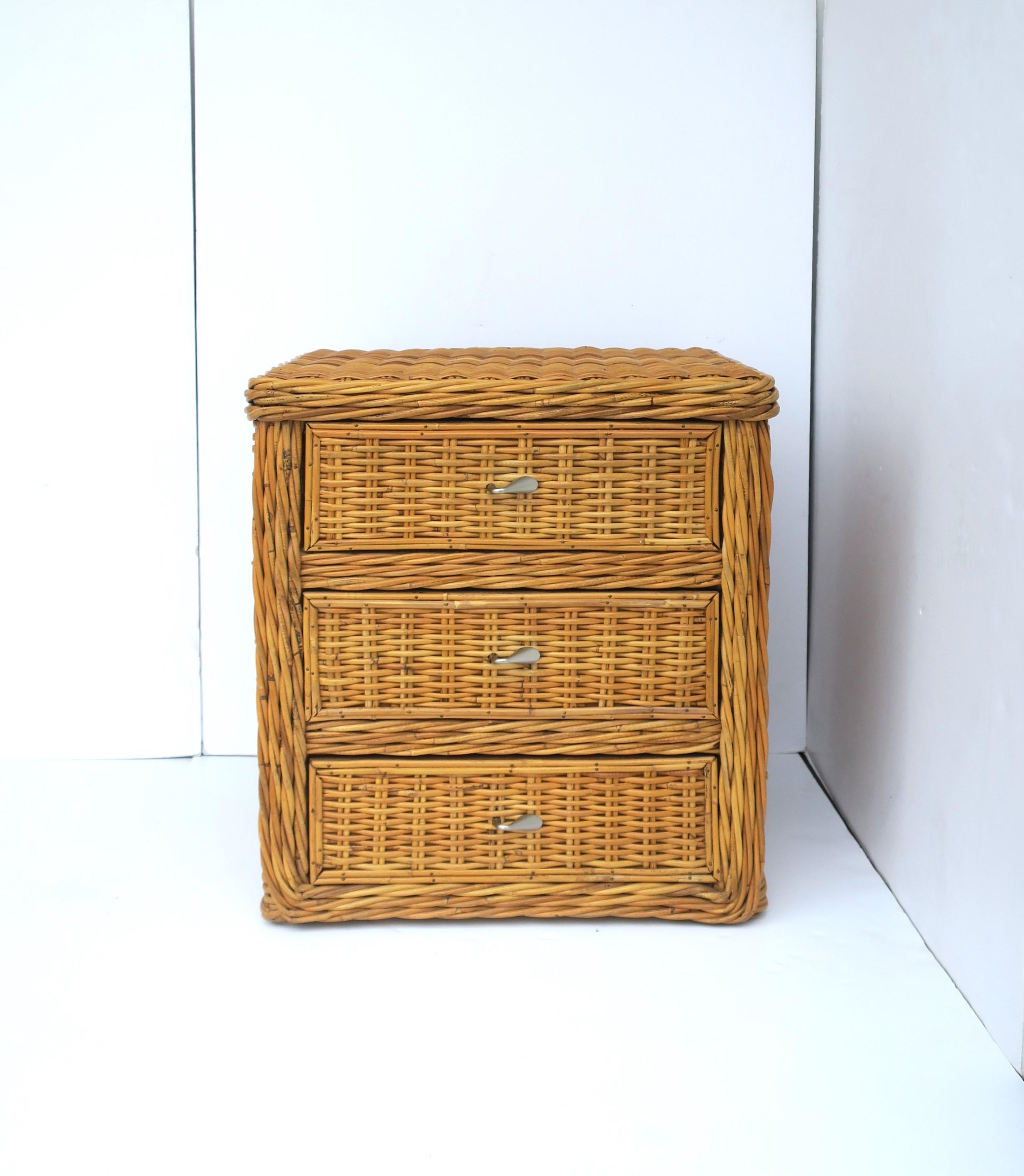 A wicker rattan nightstand or end table with storage draws, in the style of McGuire Furniture Co., circa late-20th century. Table is well made with three storage draws, all with an easy open/close. Use as a nightstand/bedside table or end table,