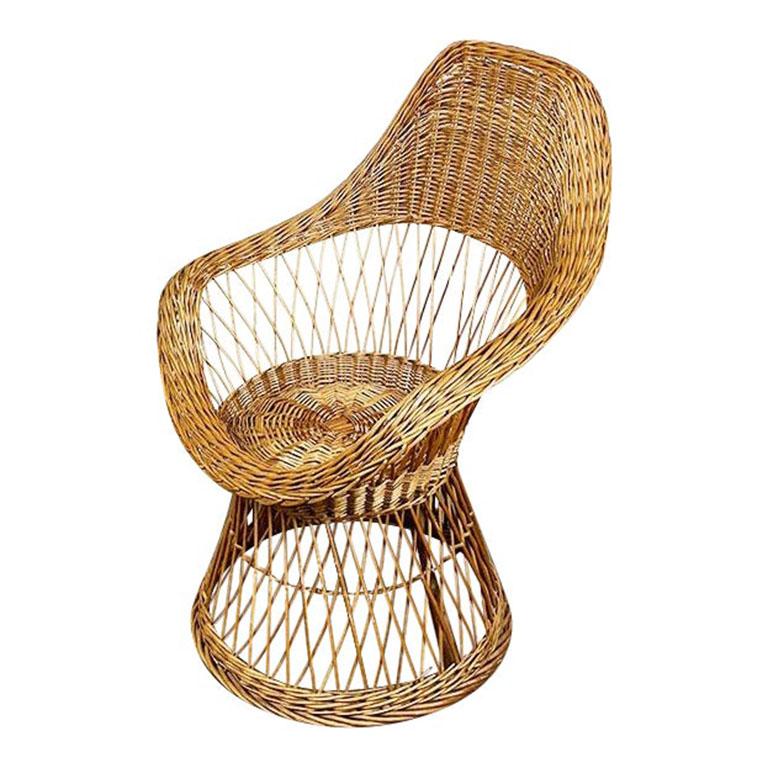 A beautiful vintage wicker patio or garden chair after Russel Woodard. Brown in color, this piece is woven in an overlapping diamond pattern. The base is round, with larger woven diamonds. The chair portion features a back and arms, woven in tighter