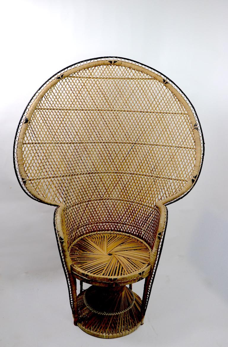 Nice clean wicker Peacock chair in the style of the iconic Emmanuelle chair. This example shows minor cosmetic wear, normal and consistent with age. Original, clean and ready to use. Arm H 29 inch x seat H 18 inches. Dramatic, chic and stylish
