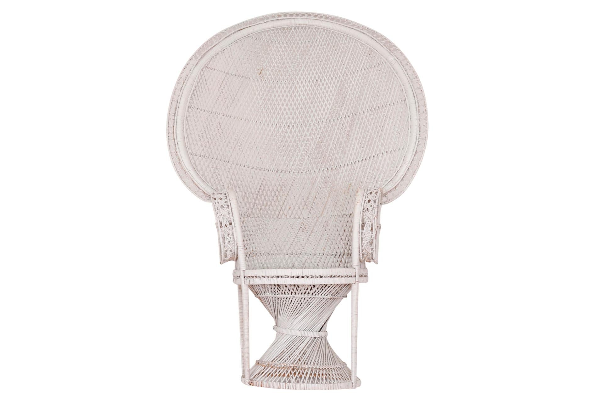 An iconic wicker peacock chair in white. A large fan back is decorated with a circular woven trim and scrolled arms are finished with plaited details. Arm height 27.25