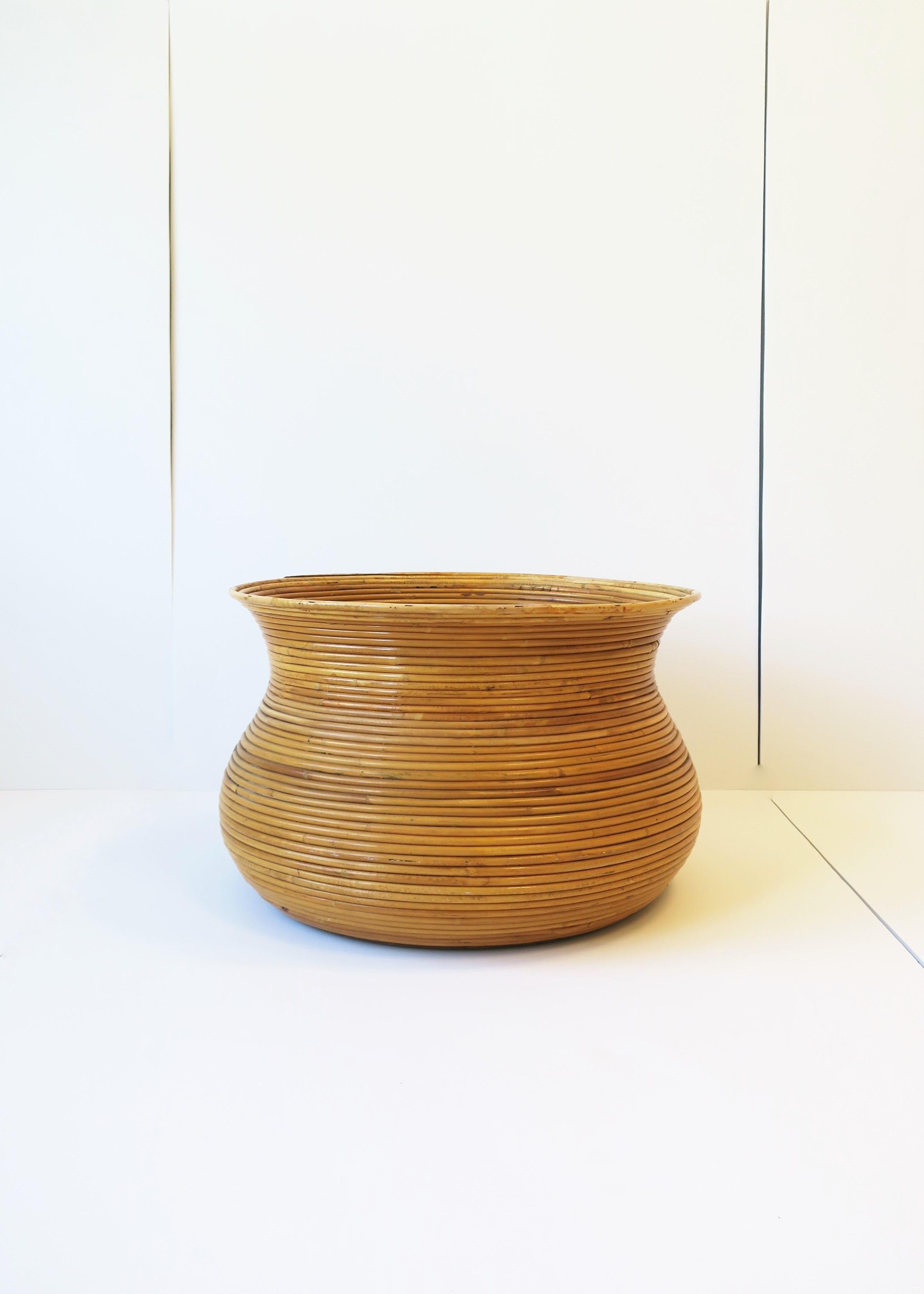 A relatively large wicker pencil reed rattan cachepot plant pot holder in the style of designer Gabriella Crespi, circa mid to late-20th century, 1970s. Overall dimensions: 11.75