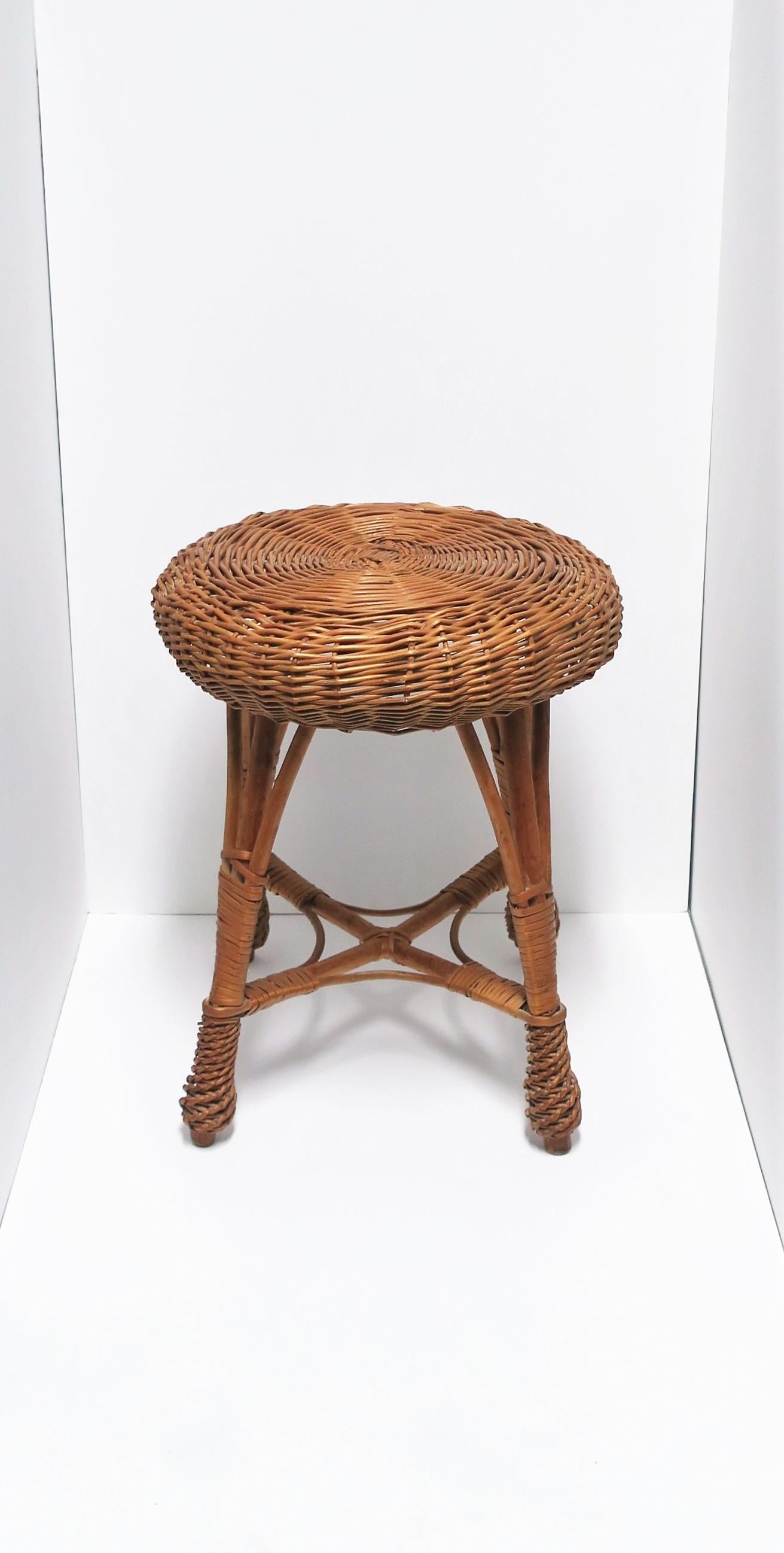 A vintage round wicker stool, circa mid-20th century, USA. Piece could also work as a side or drinks table providing there's a stable environment on top for drink (e.g. coffee table book.)

Piece measures: 15