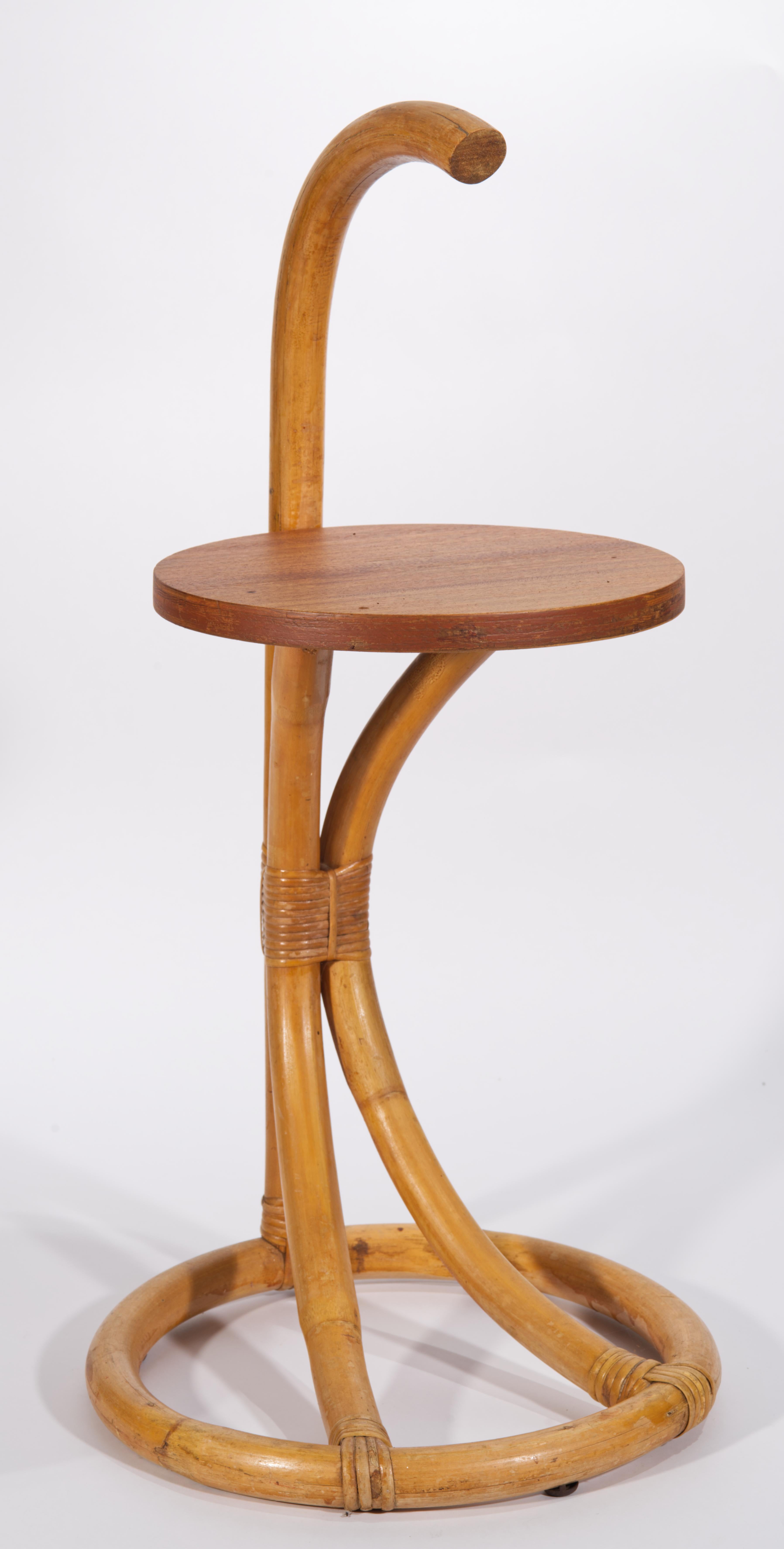Vintage bamboo and rattan side table features a rounded top handle, stable round base, and mahogany veneer top. Charming, statuesque table can be used as either an occasional or drinks table, and the convenient handle is allowing for an easy way to