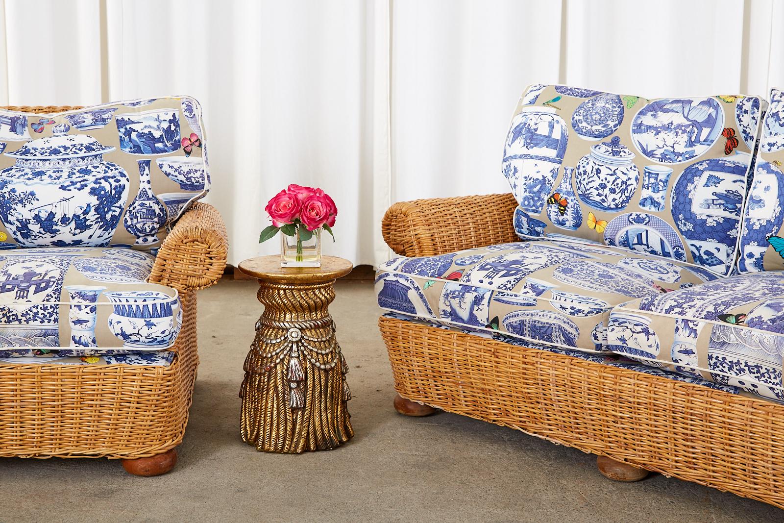 Organic modern living room set consisting of a settee and an armchair featuring chinoiserie style blue and white ginger jar motif fabric. Crafted from rattan frames covered with woven wicker. The set has generous seating areas topped with thick