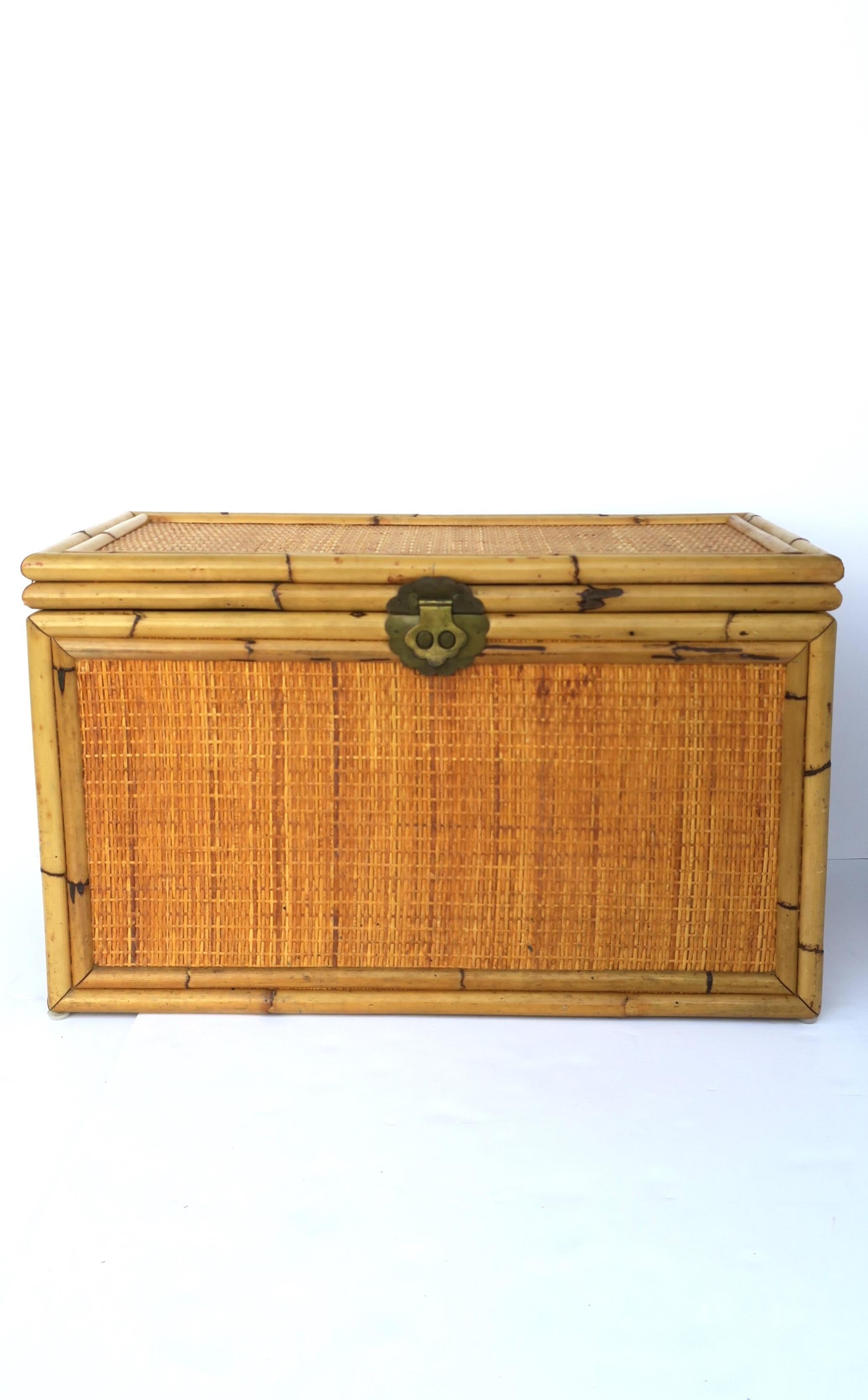 A wicker bamboo and brass storage chest trunk box in the Chinoiserie style, circa 1970s. This wicker storage chest has decorative brass front closure, brass loop handles on two sides, and brass hinges. In addition to being a storage chest trunk