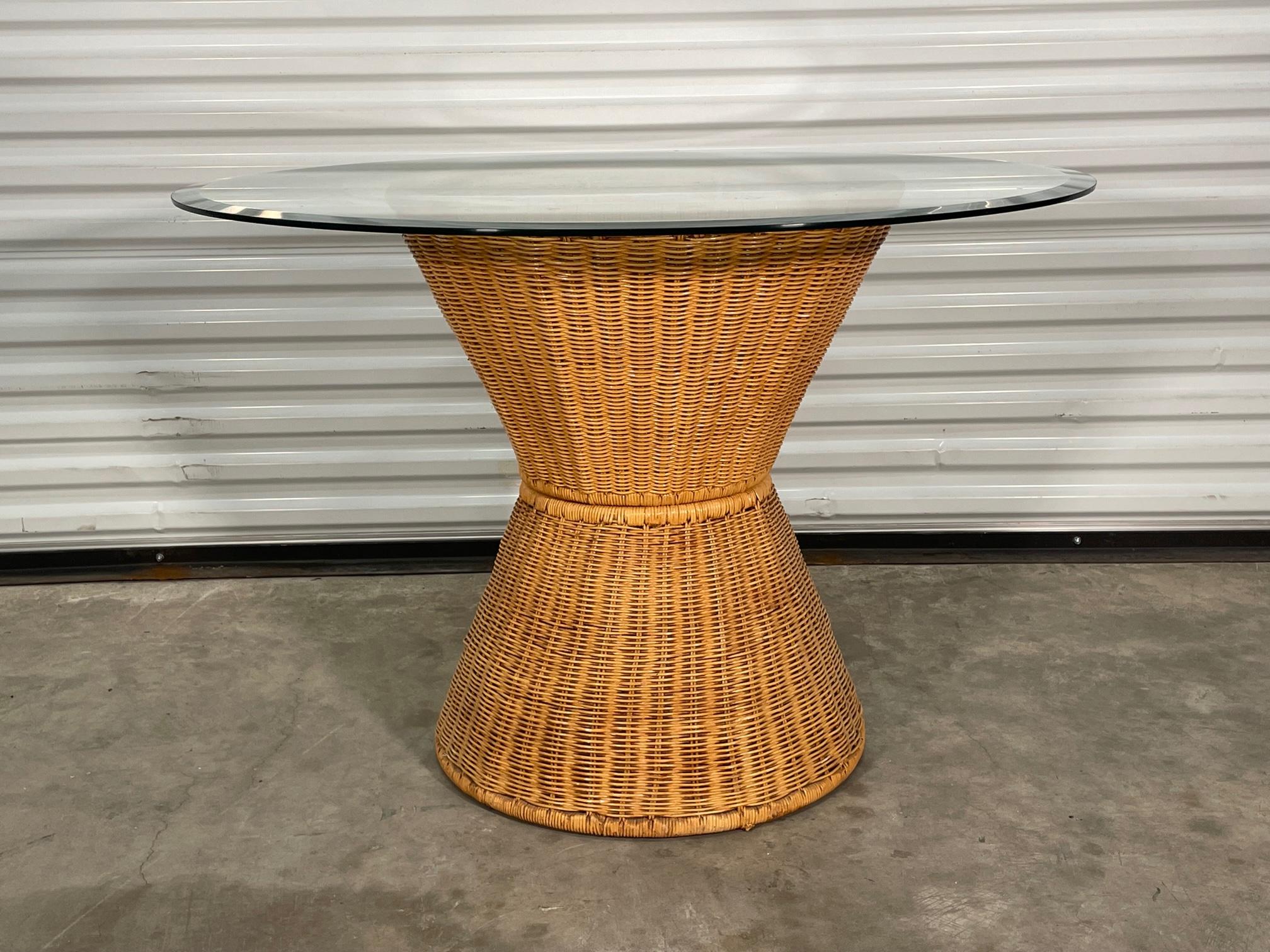 Vintage wicker dining table features an hourglass shaped pedestal base and 42