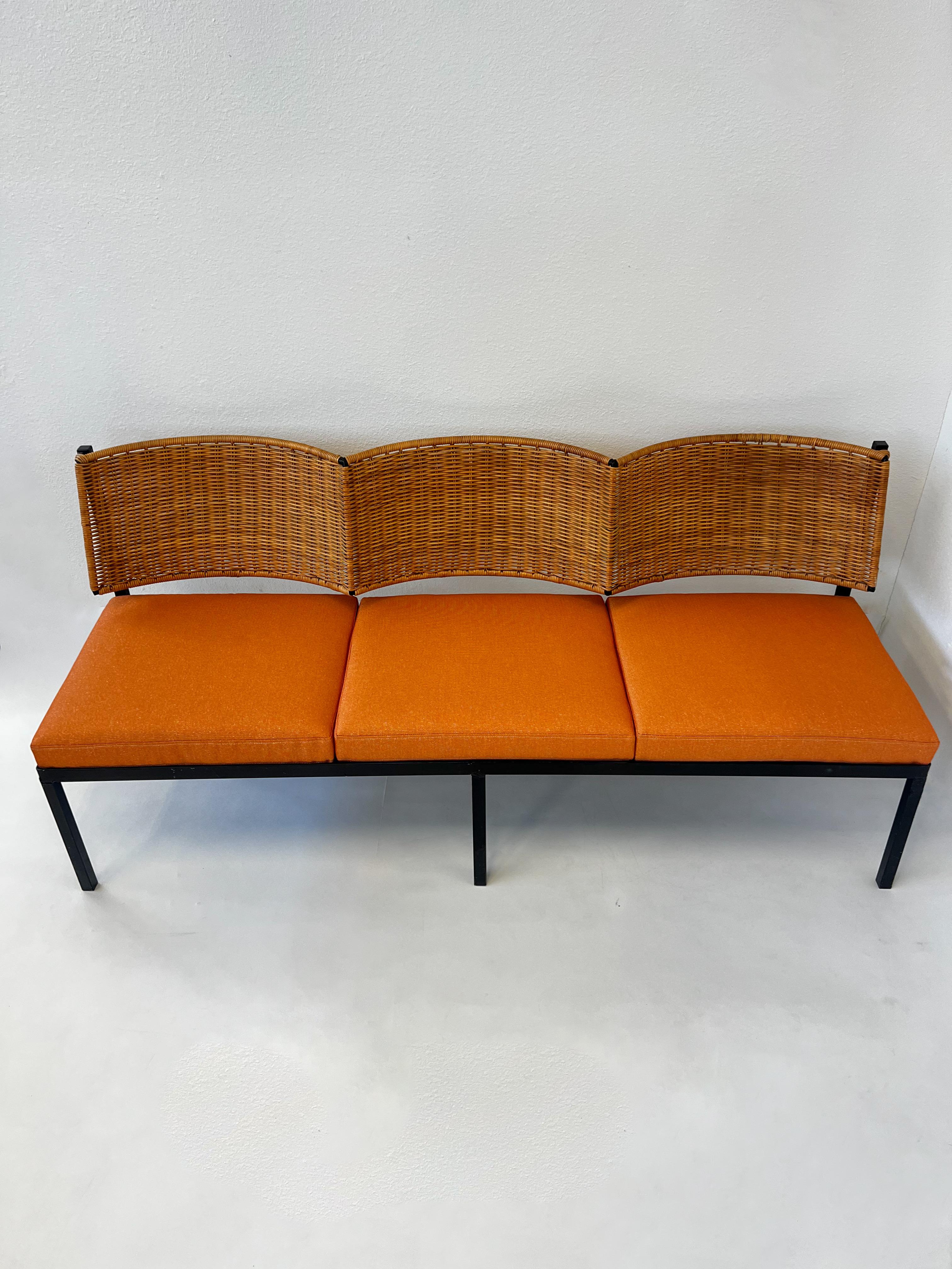 Scalloped wicker back three seater sofa from the 1960’s. 
Constructed of black lacquered steel, wicker and orang with gold threads Sunbrella fabric cushions. 
In great condition. The cushions are new, some repairs were made to the wicker( see detail
