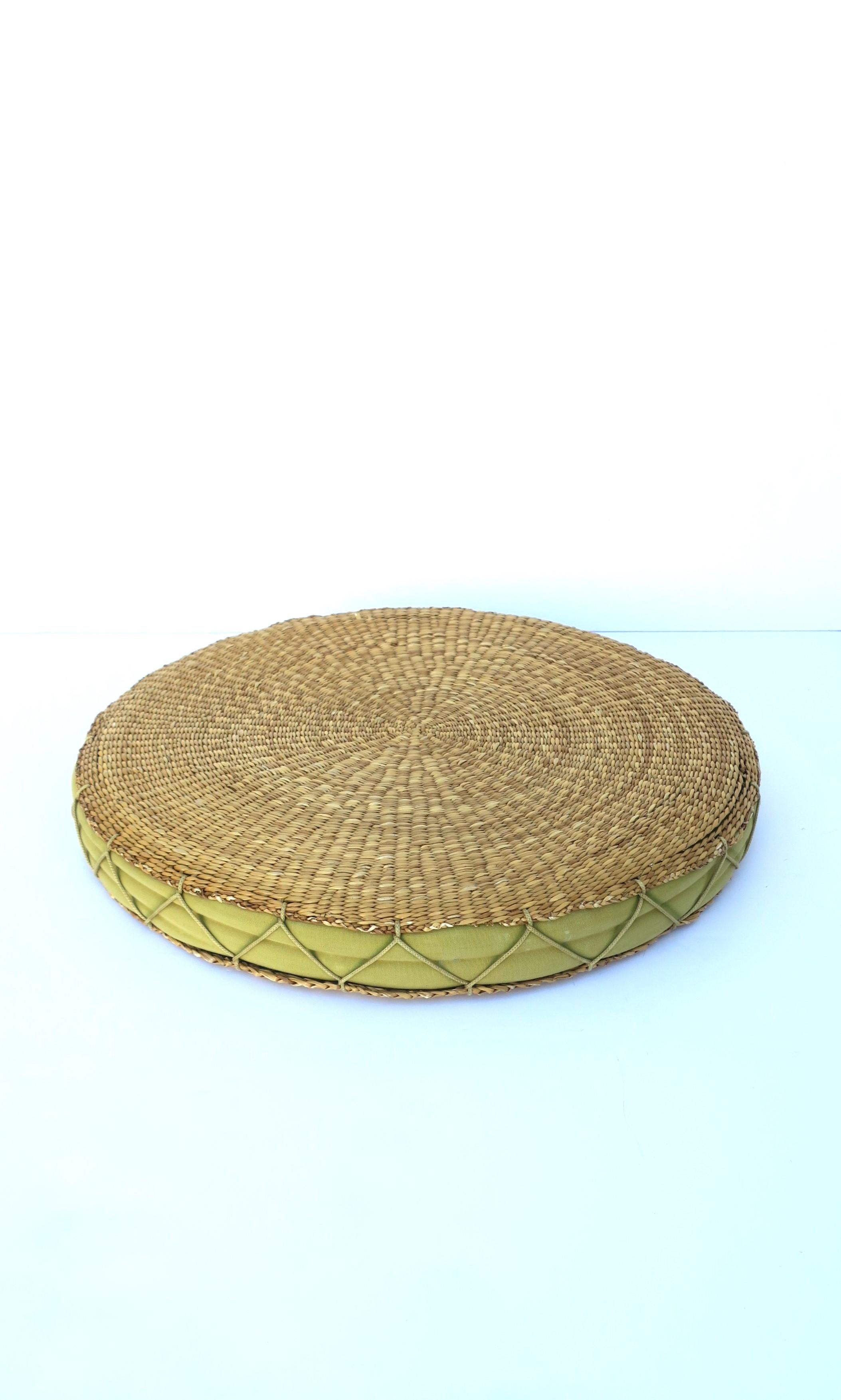 A vintage wicker light-green seat or floor cushion with cotton insert and large 'X' stitching around, circa mid to late-20th century. Piece could also be used as a tray to hold light items as demonstrated with coral piece. 

Dimensions: 18