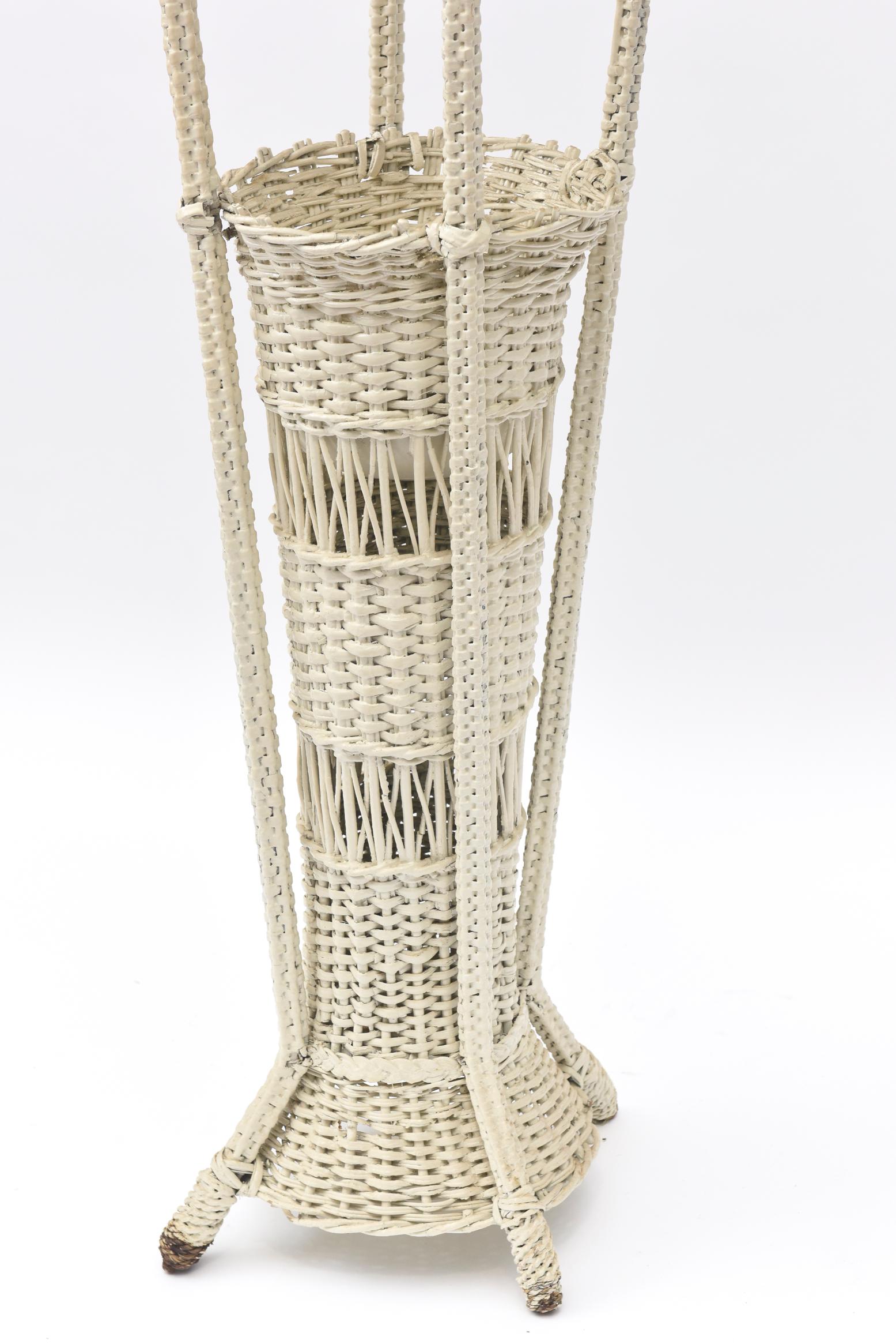 A rare example of early 20th century wicker woven floor lamps, this one has a base which is a large vase or even an umbrella stand. Both the wicker base and the wicker shade are openly woven. There is a metal insert for water should you insert