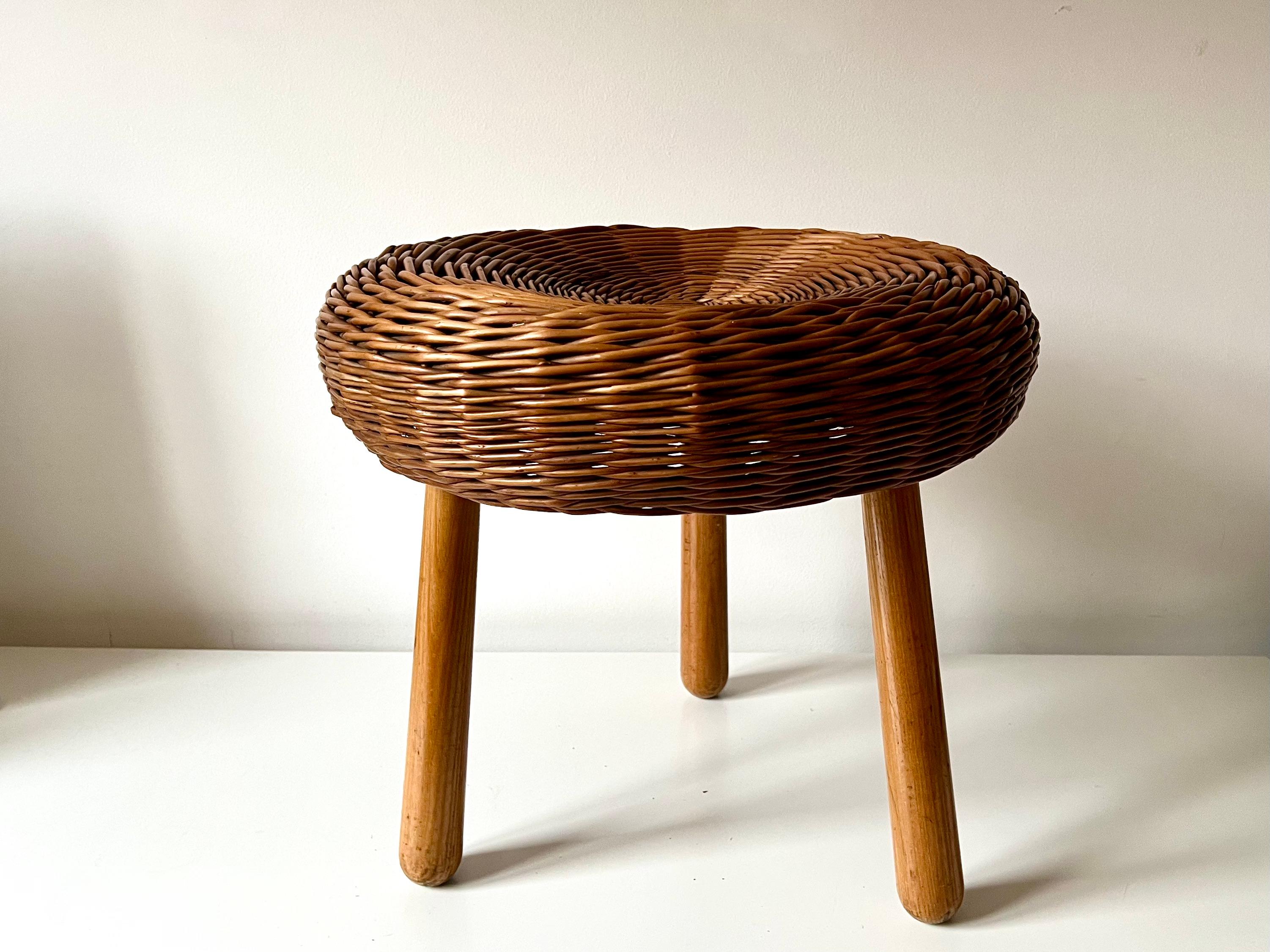 Vintage tripod stool in the manner of Tony Paul.

Woven wicker circular seat on beech legs. The stool has aged nicely and has a great colour. The woven wicker weave remains in very good condition.

Original vintage condition. No repairs or