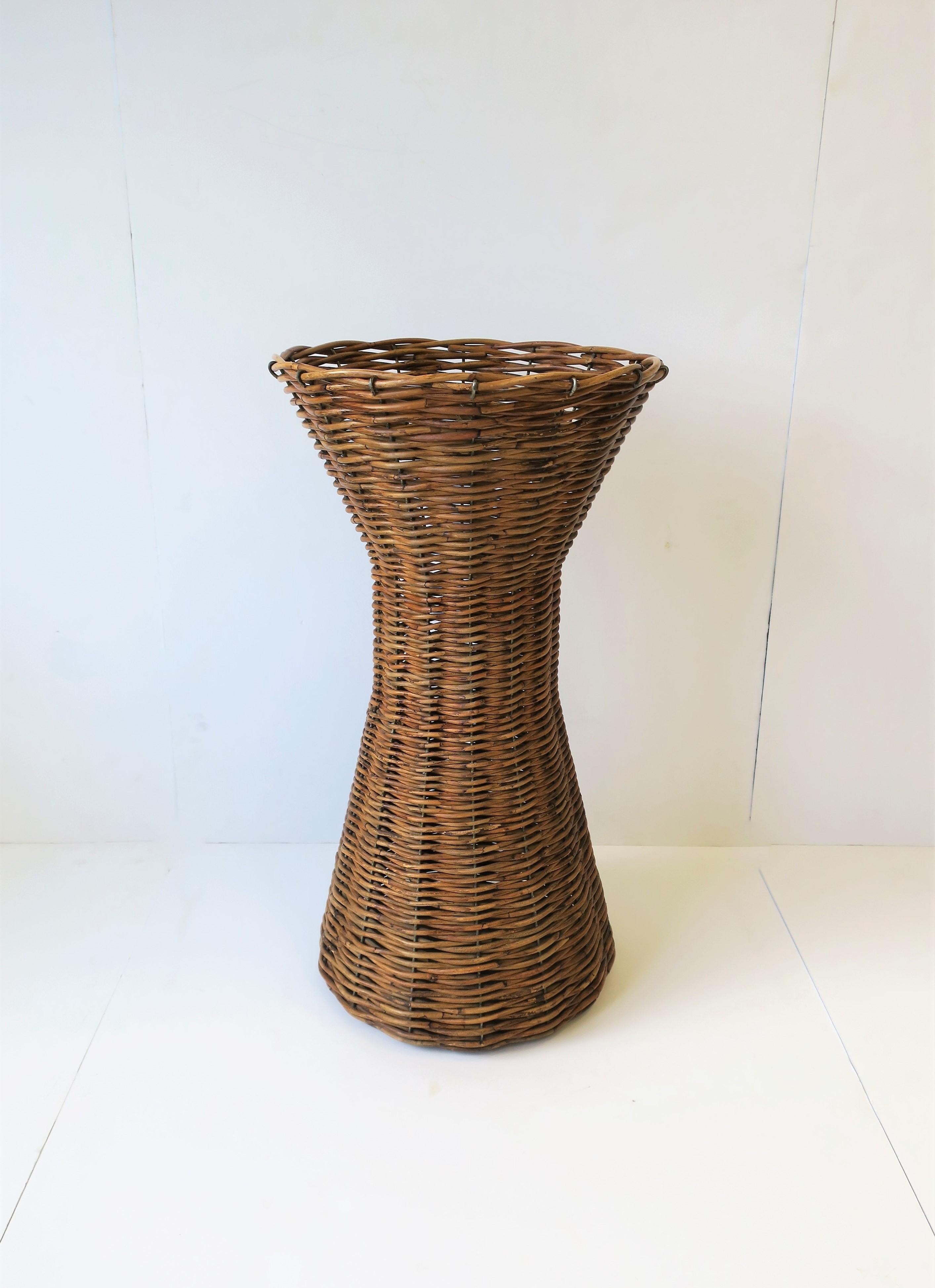 A tall wicker vessel/vase. See image #6 for size perspective. 

Measurements: 26