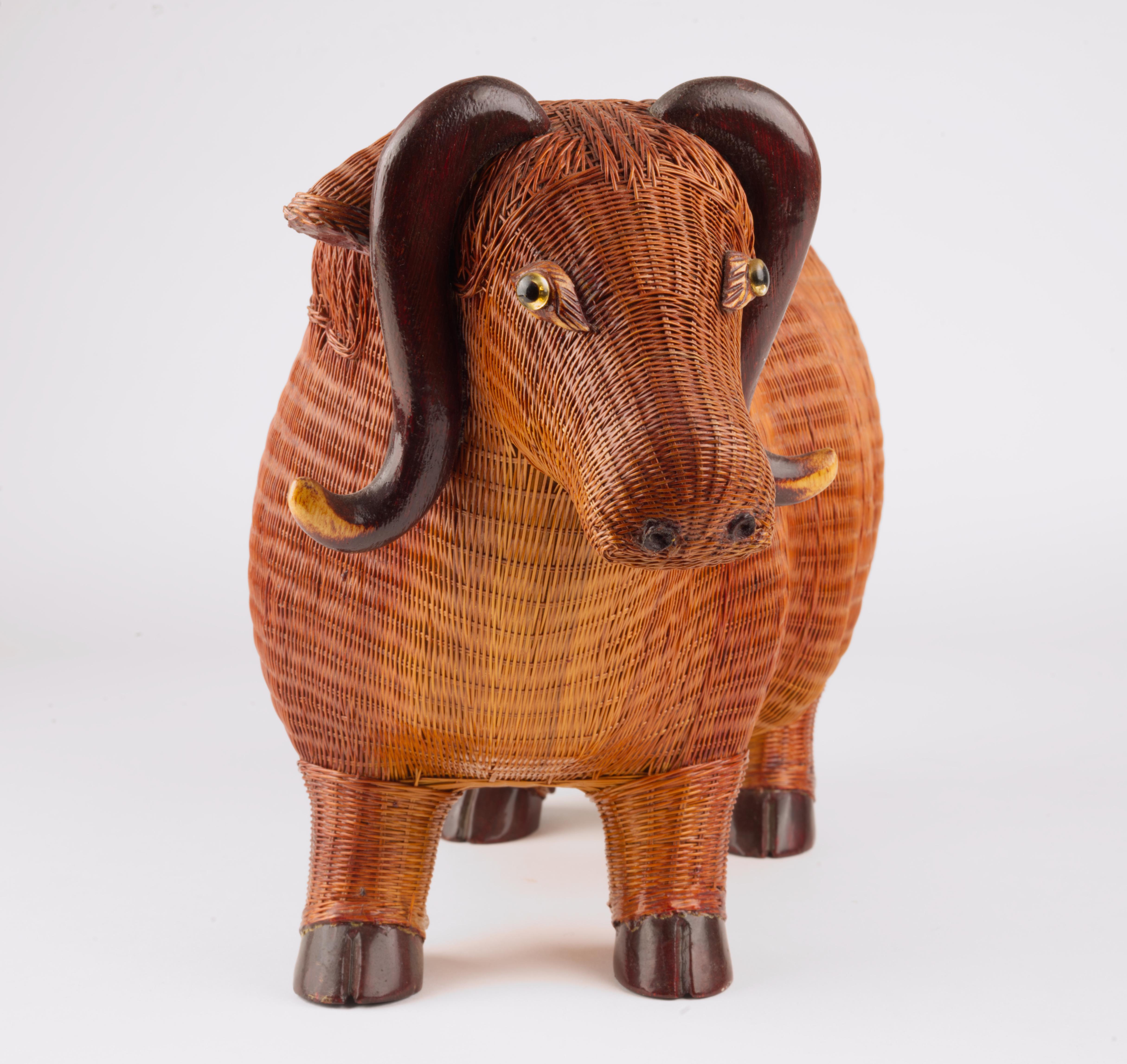  A highly detailed, sculptural water buffalo figurine was hand made in finely woven lightweight honey-brown wicker which was then lacquered, with carved wood feet and horns and clear and black glass eyes, by Shanghai Handicrafts Collection.

The