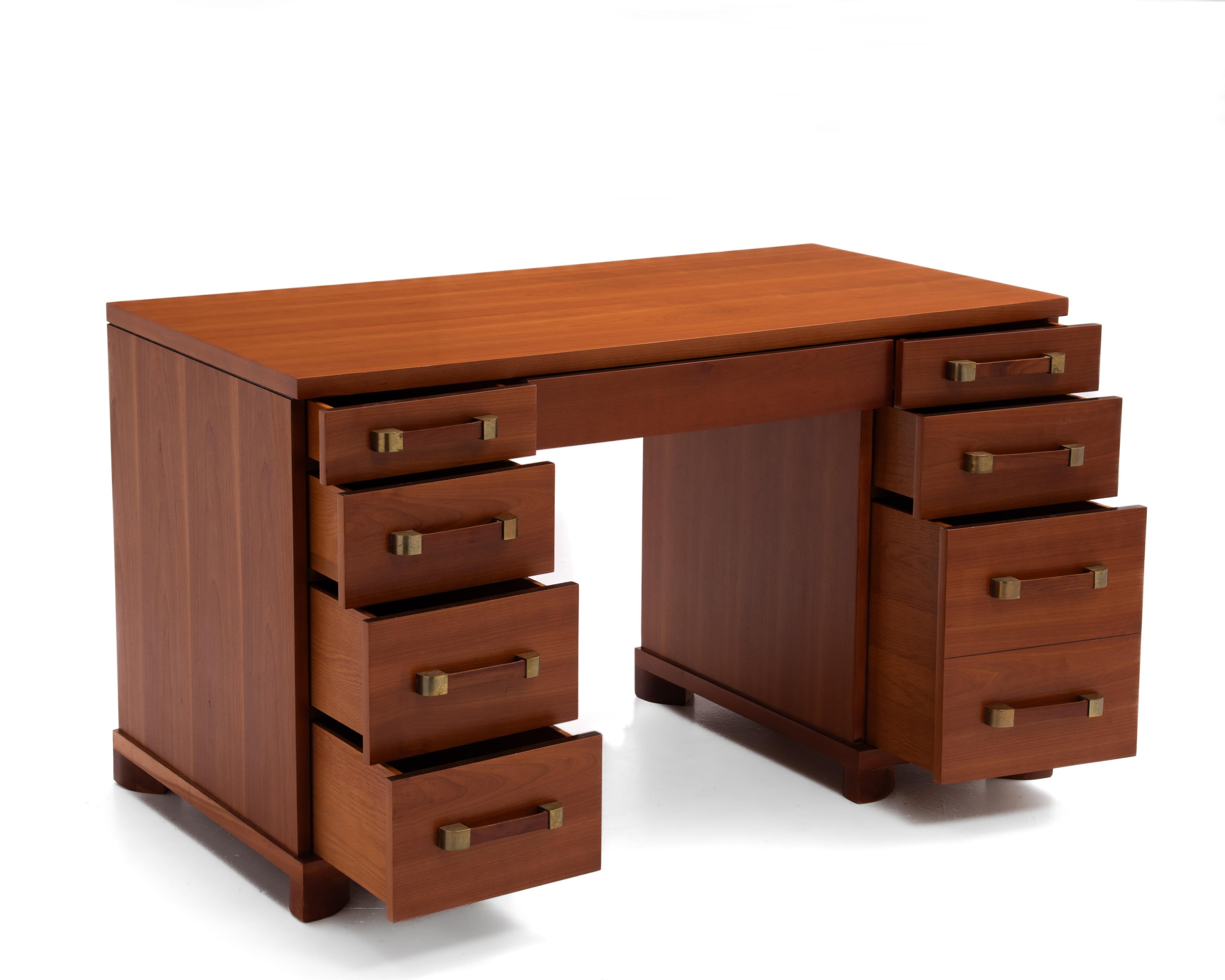 Una scrivania direzionale a ginocchio Widdicomb non marcata. Ottima scelta del legno, libro abbinato in tutto e per tutto. Impiallacciatura in ciliegio con piedi in ciliegio massiccio. Patina originale sulle maniglie in ottone. Restaurata