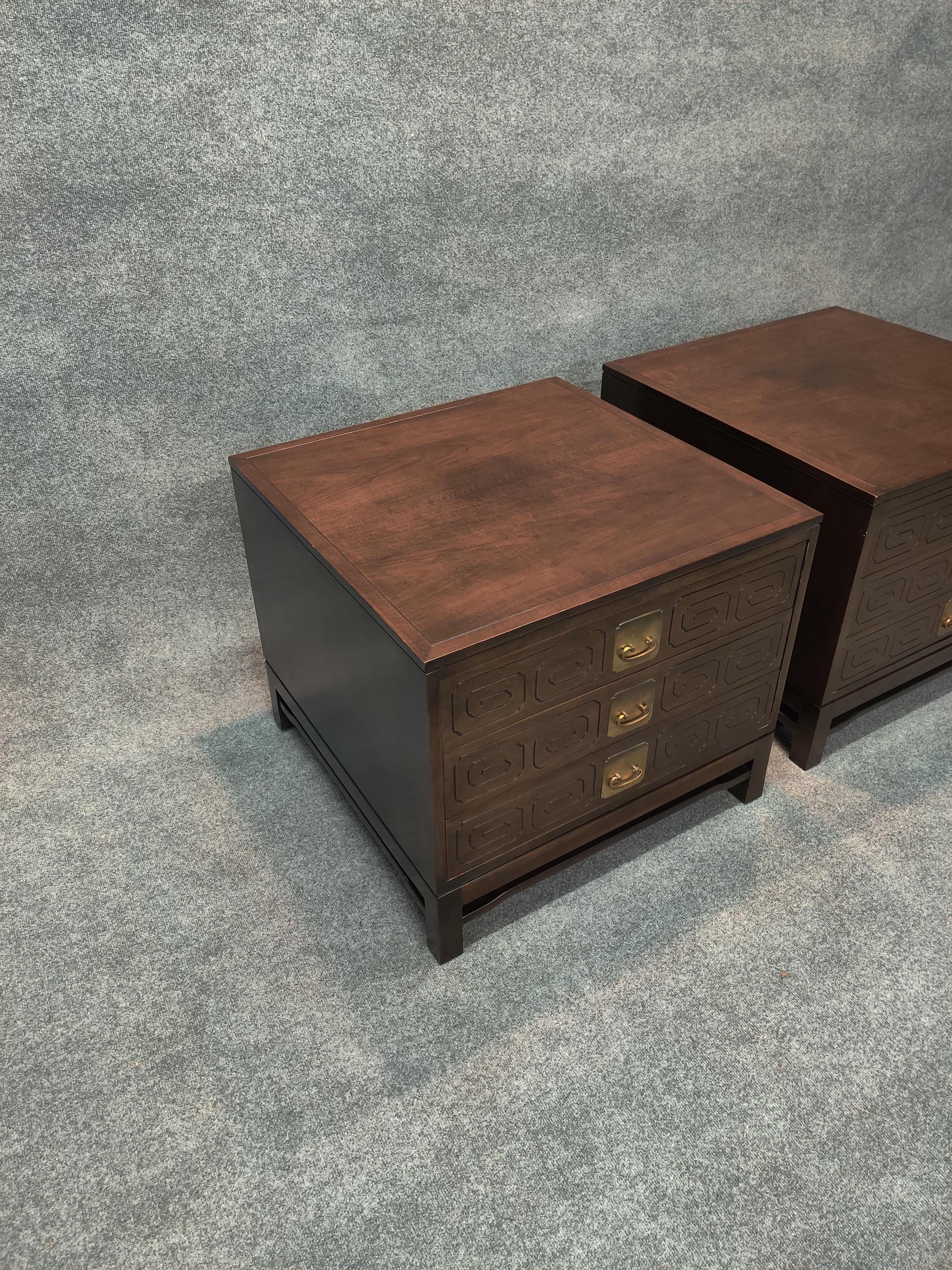 Pair of large sofa tables or nightstands in walnut. Three drawers each with carved Mandarin design and brass handles. Labels to each, finished backs. Good vintage condition with minimal scuffs, scratches, and minor dings.