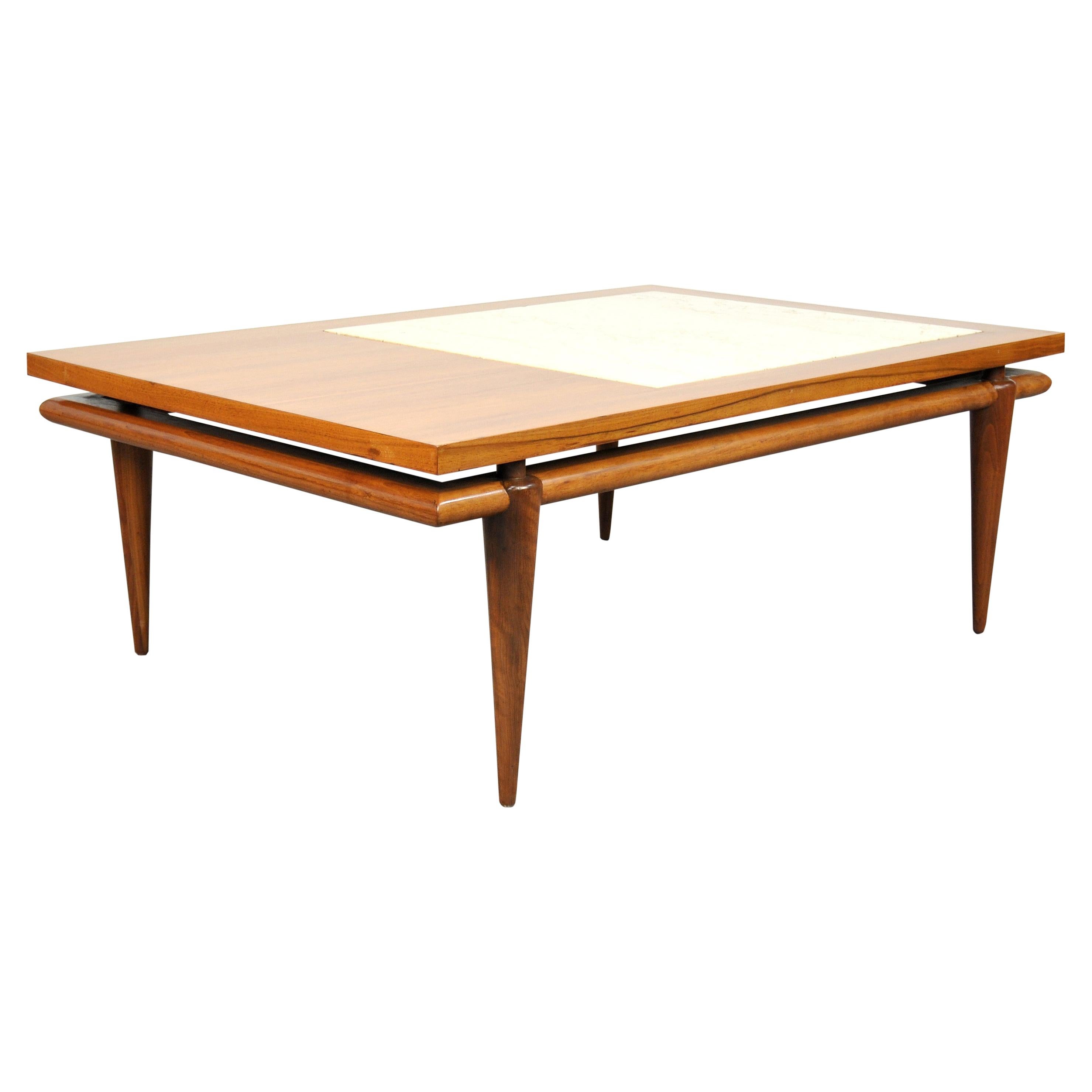 A gorgeous vintage walnut and travertine marble midcentury modern cocktail table, possibly designed by Robsjohn-Gibbings and manufactured by Widdicomb. The table features a rectangular top with inset white travertine marble floating over a base with