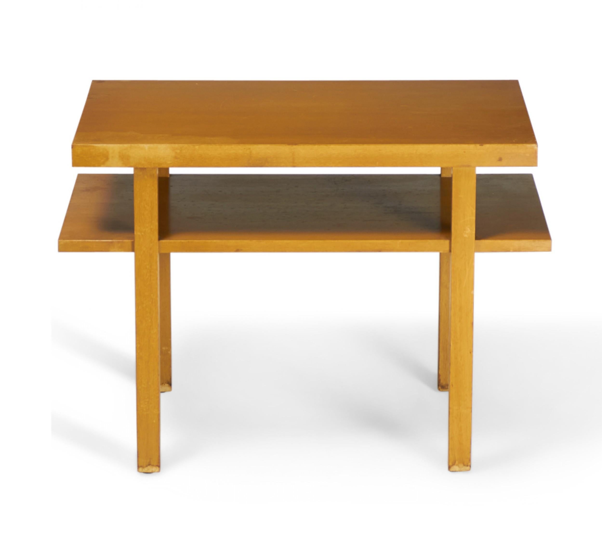 American mid-century (circa 1950) 'Cantilever' blond maple end / side table with a rectangular form, lower shelf that extends beyond the plane of the tabletop, and four square legs. (Widdicomb).
     