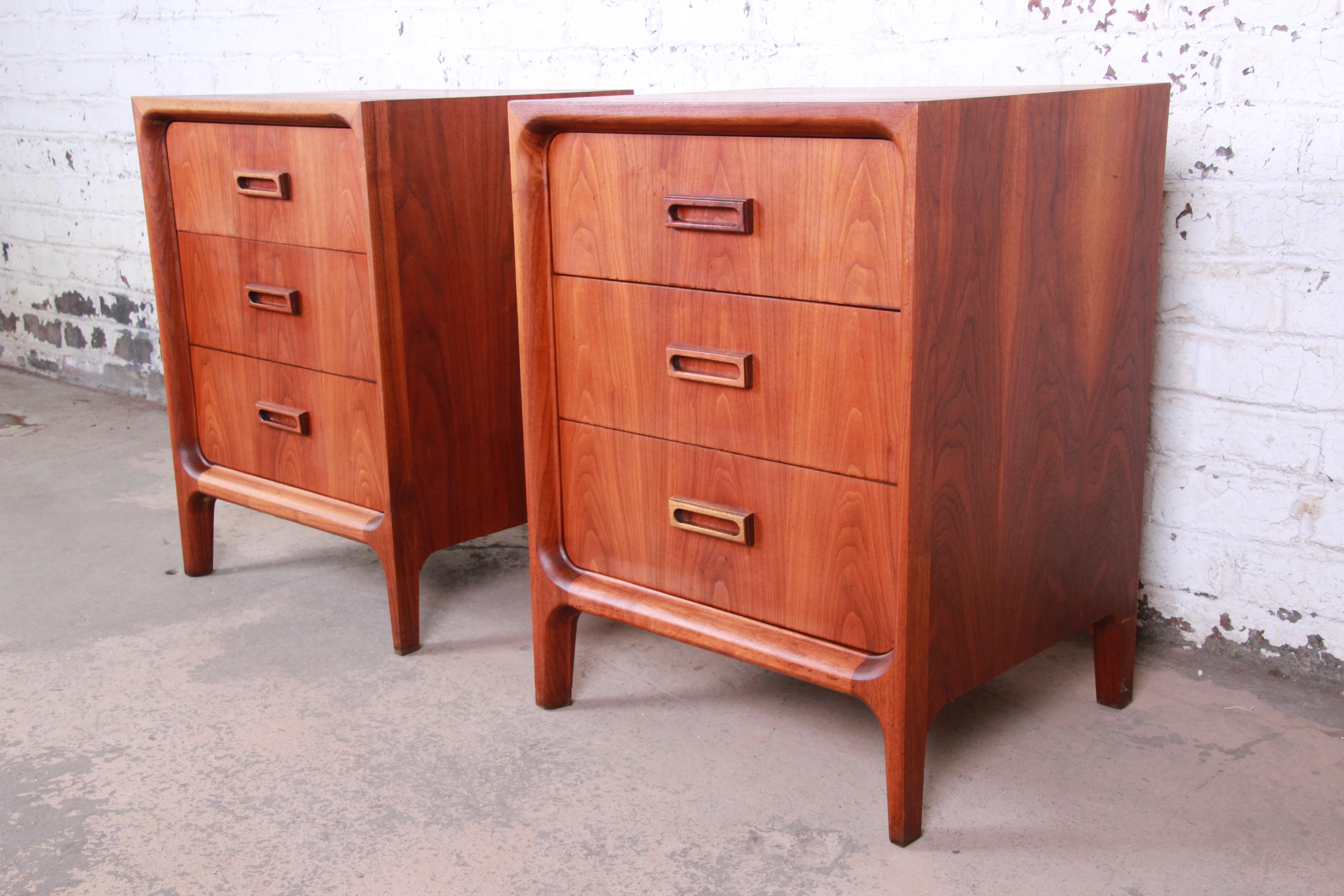 An exceptional pair of walnut three-drawer bachelor chests or nightstands by Widdicomb Furniture of Grand Rapids. The chests feature gorgeous walnut wood grain and sleek mid-century design. They offer ample storage, each with three deep dovetailed