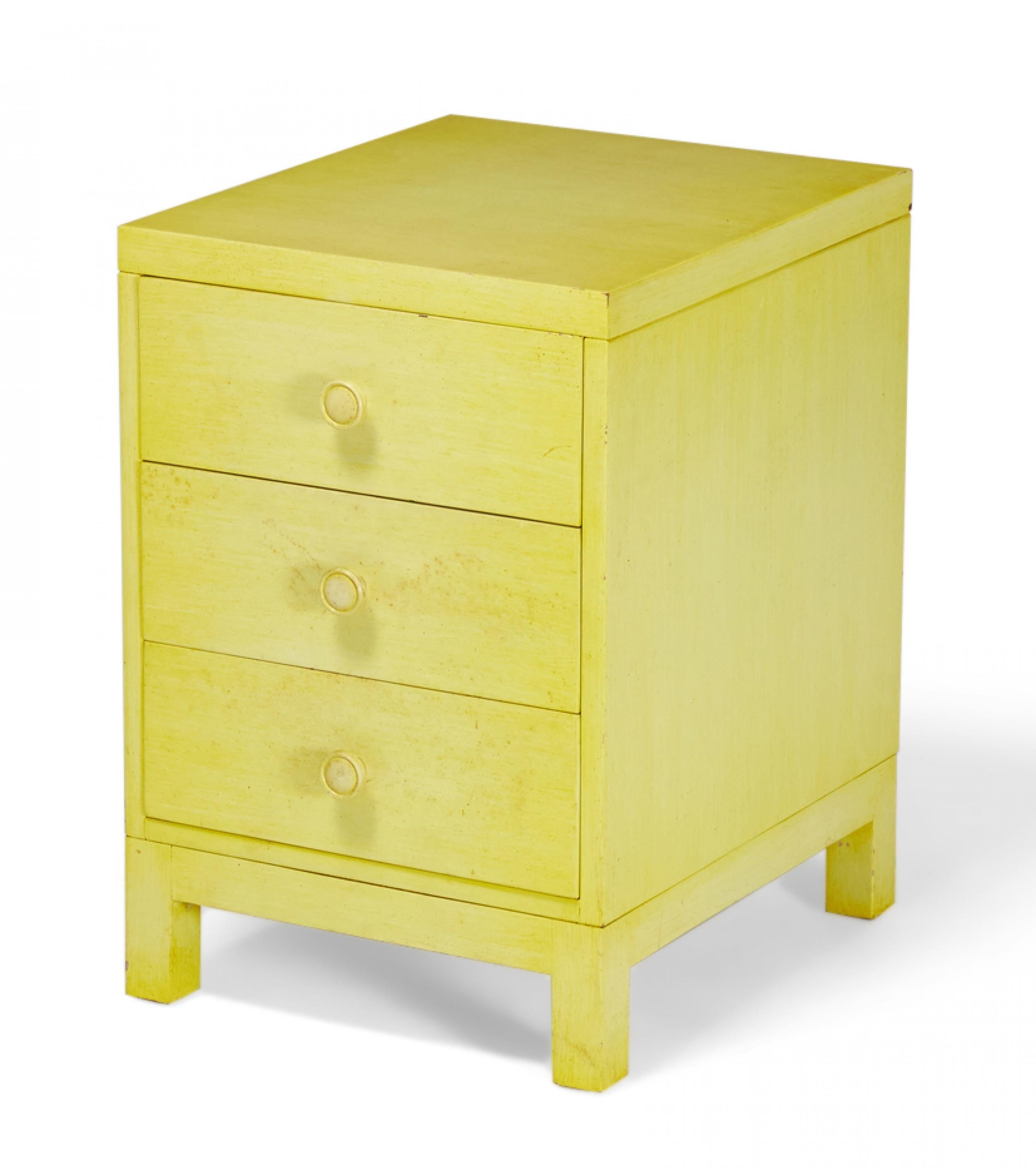 American Mid-Century beige painted walnut bedside table / nightstand with three drawers with circular beige painted drawer pulls resting on four square legs. (Widdicomb Modern)(Similar nightstands: DUF0155A, DUF0155C).
     