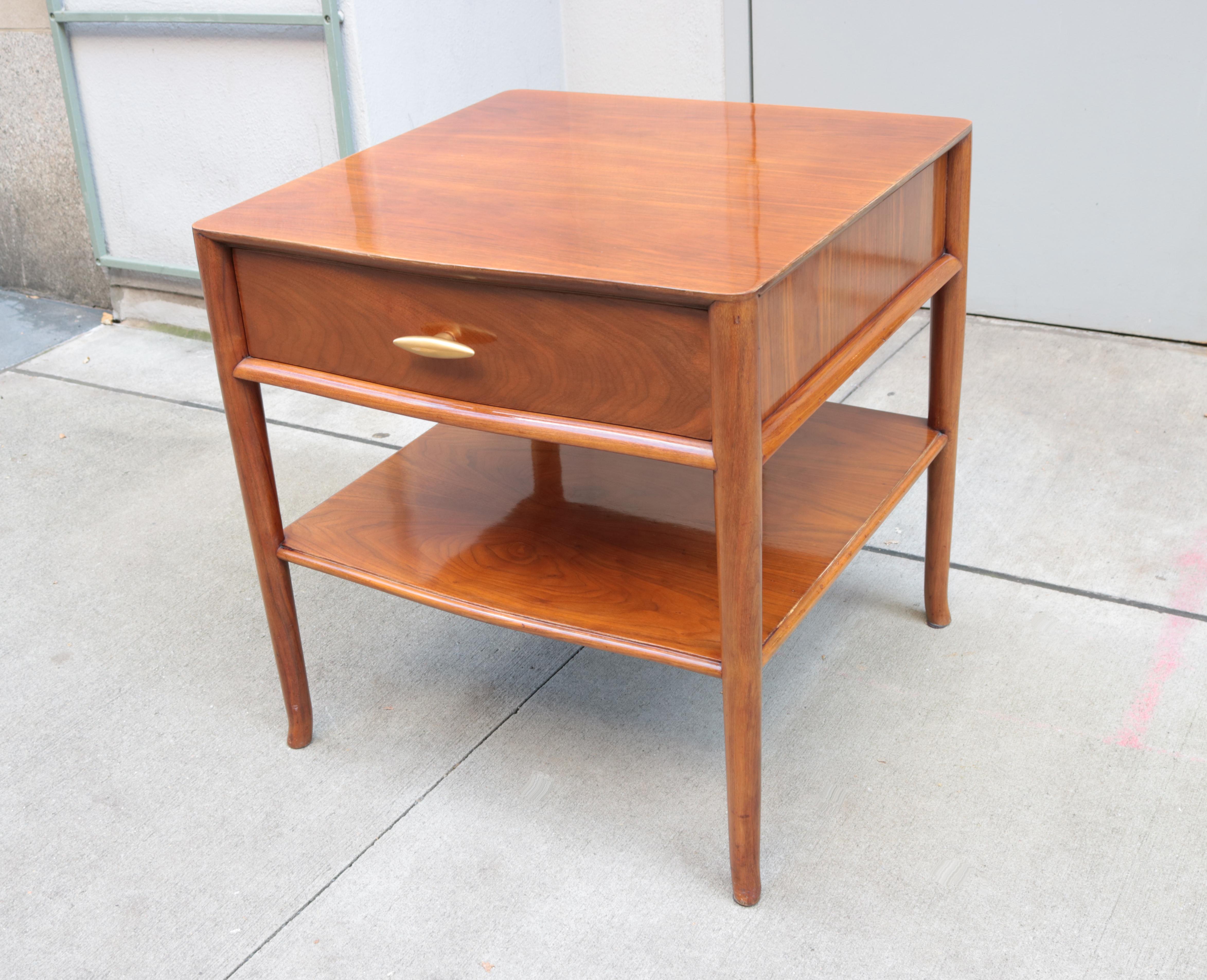 A modernist two tier side table with single drawer.
Designed by T.H.Robsjohn-Gibbings for Widdicomb.
Walnut with original glazed gold porcelain pulls.
Featuring the original Widdicomb labels.