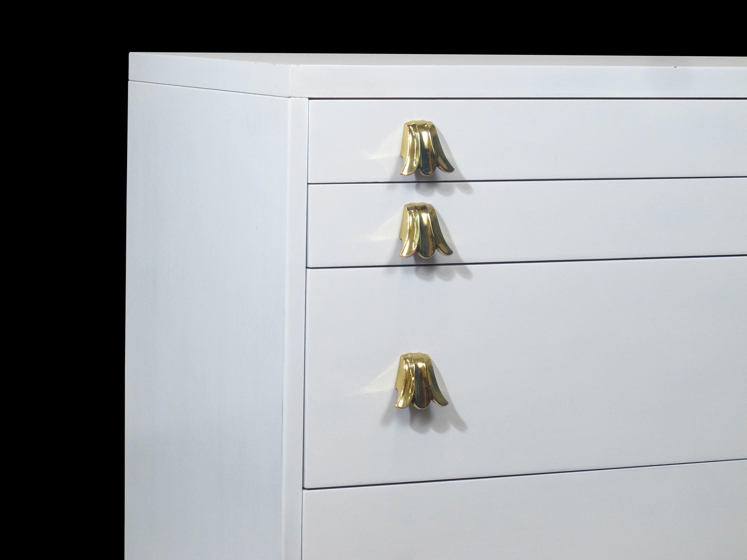 Mid-Century Modern chest of drawer cabinet designed by C.G. Kimerly for Widdicomb finished in a white lacquer with brass plated flower shaped drawer pulls.