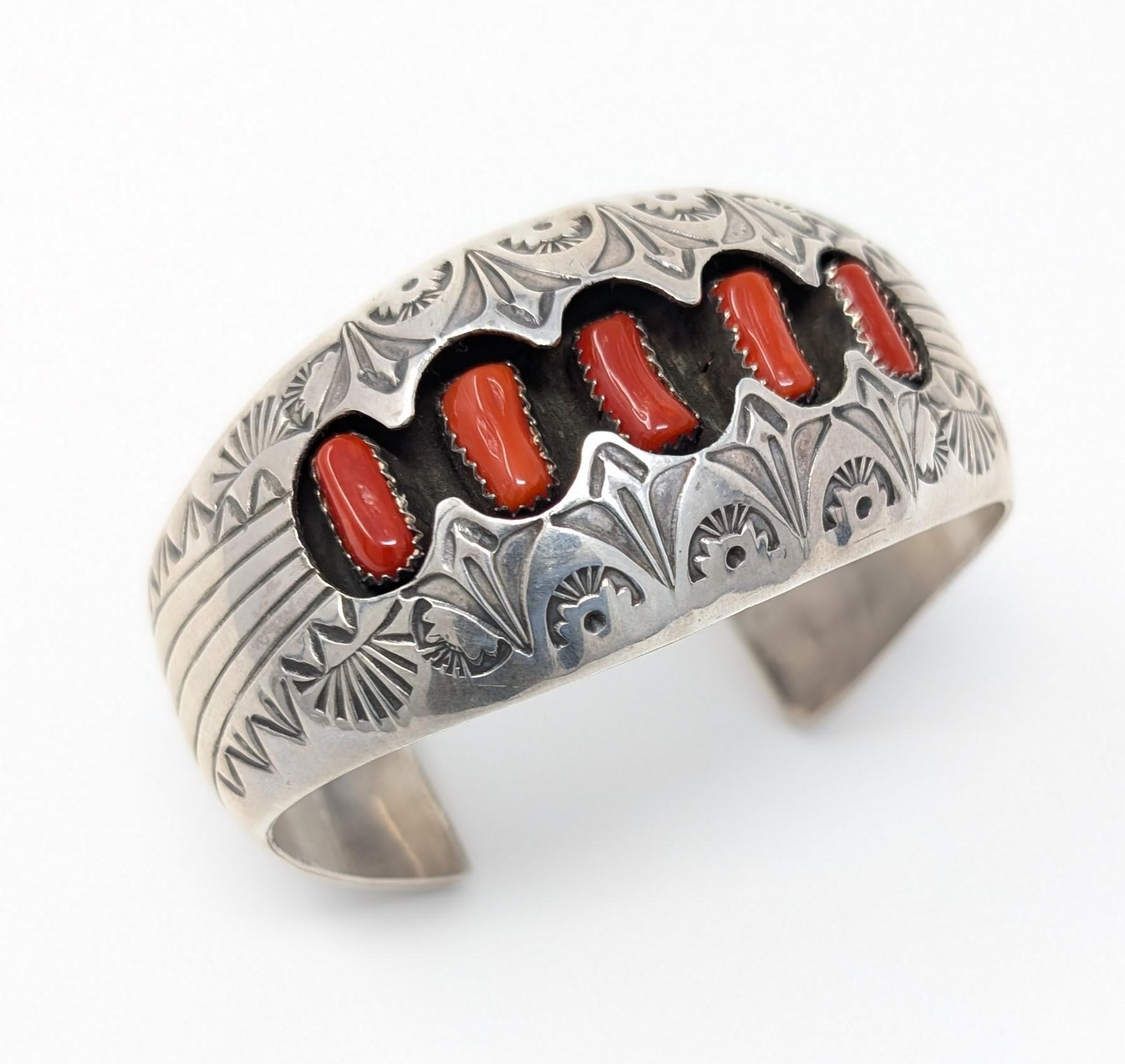 Manschettenarmband aus 925er Sterlingsilber mit Stempeldesign und Schattenbox. Mit lebhaften Korallen-Cabochons und der Signatur P. Benally Sterling auf der Innenseite der Manschette. Maßnahmen 1,25 Zoll in der Höhe von 7,5 mm in der Tiefe, hat eine