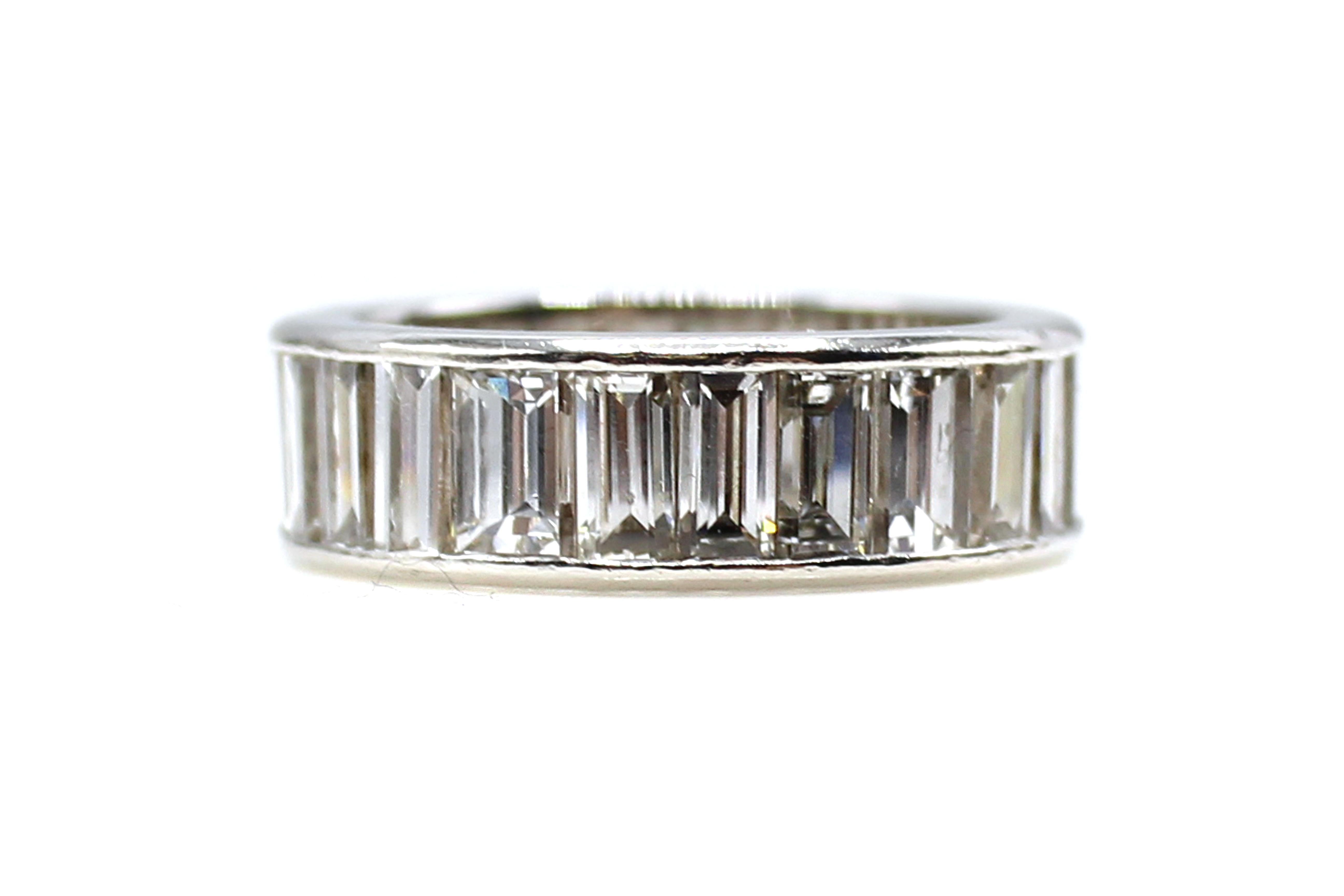 This exquisite beautifully hand-crafted eternity band is channel set with 32 bright white and sparkly baguette cut diamonds with an approximate total diamond weight of 8 carats. The baguettes measure over 6 millimeters in length, which is quite