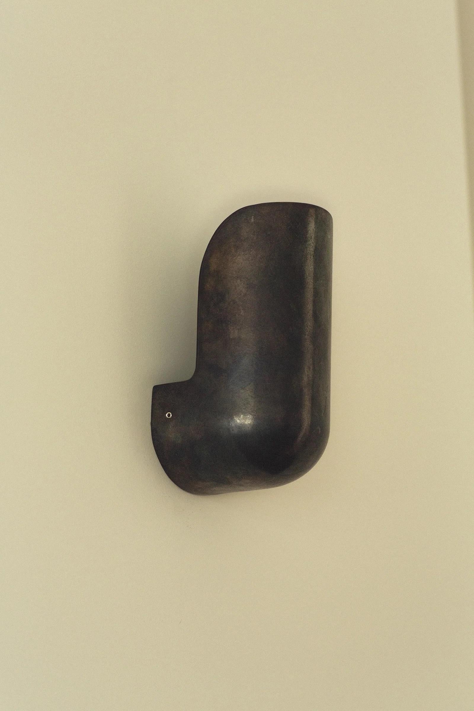 Wide Blackened Elbow Wall Light by Henry Wilson
Dimensions: W 13 x D 9.5 x H 20.5 cm
Materials: Blackened bronze.

Available in blackened, aluminum, and brass.

Elbow Wall Light is available in two widths and three material finishes. Its form